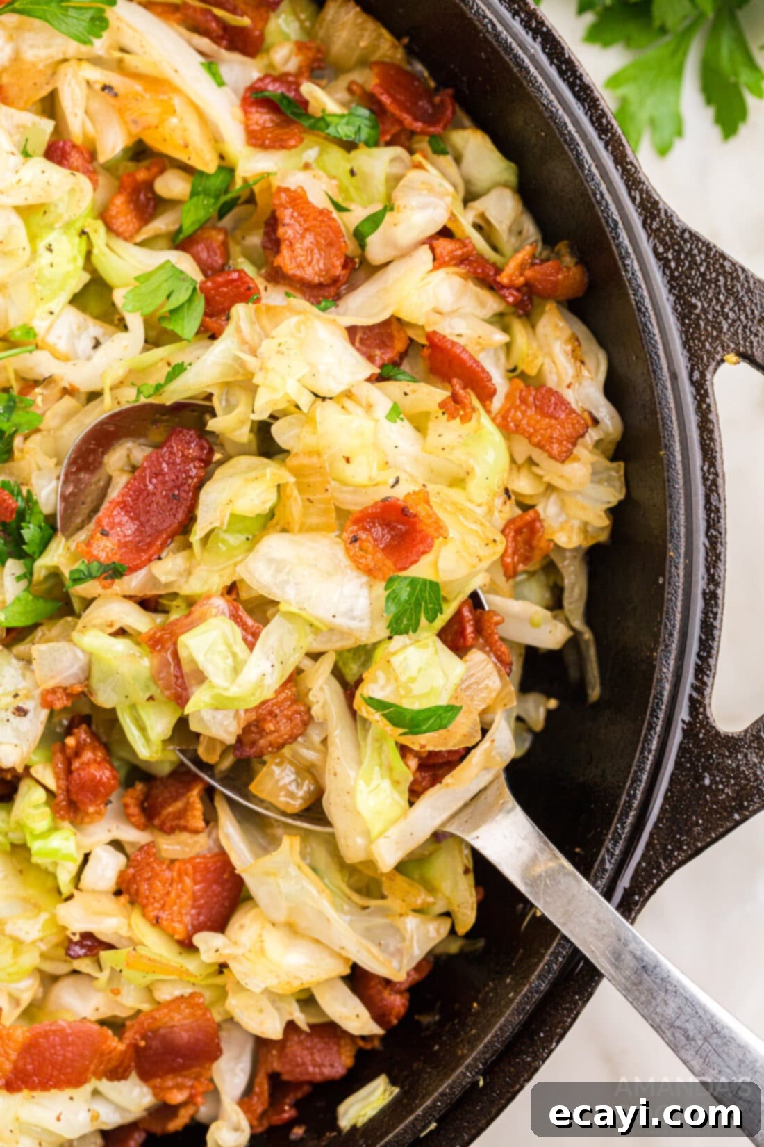 Golden Fried Cabbage 2 Fried Cabbage in pan with serving spoon