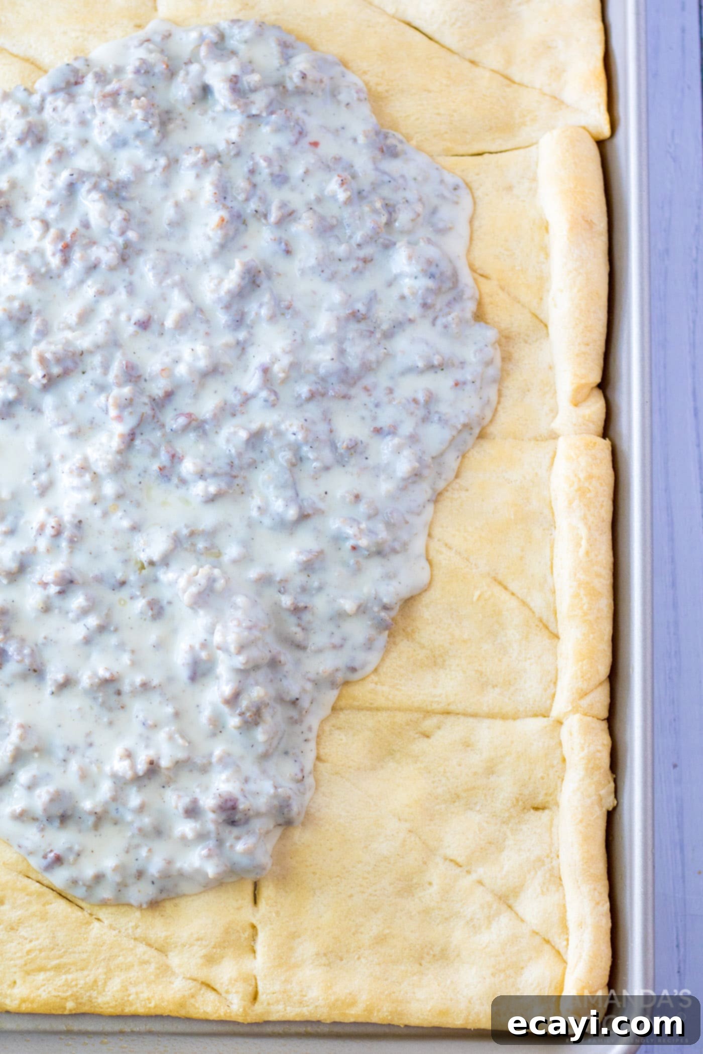 One-Pan Breakfast Pizza 6 sausage gravy on top of crescent dough