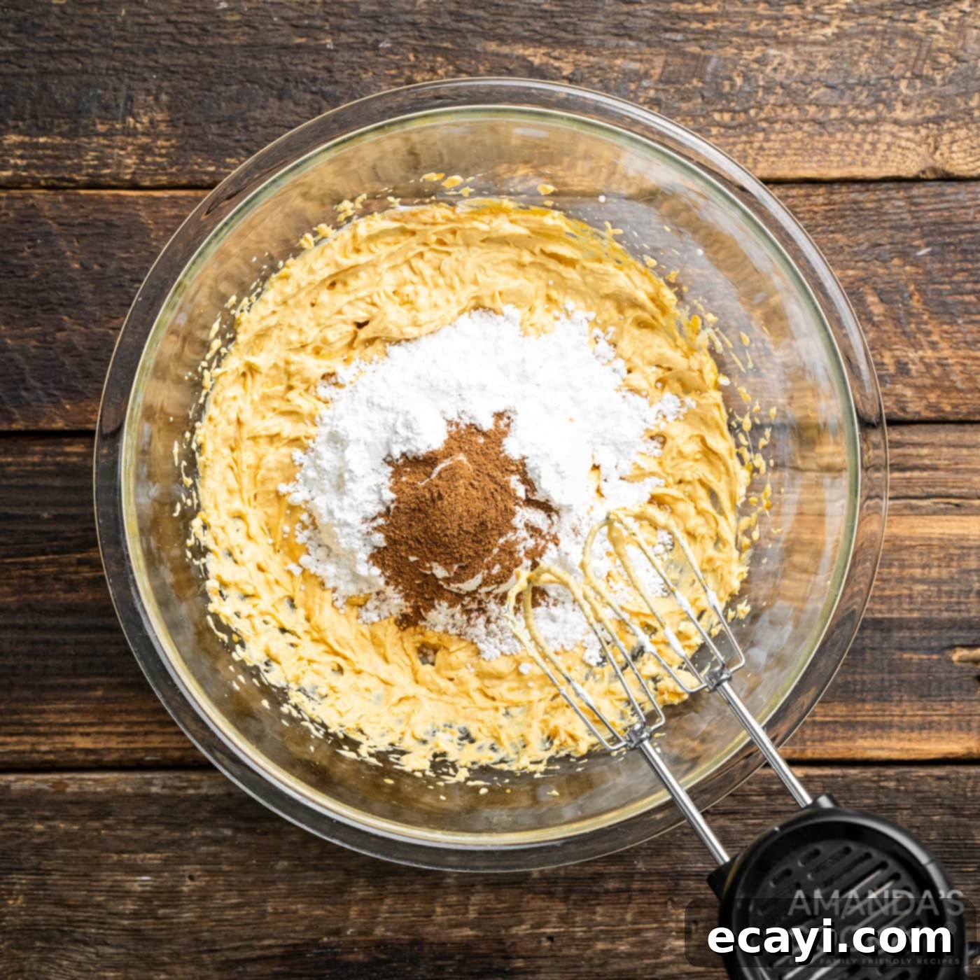 Spiced Pumpkin Pie Dip 6 hand mixer beating pumpkin cream cheese mixture with powdered sugar and spices