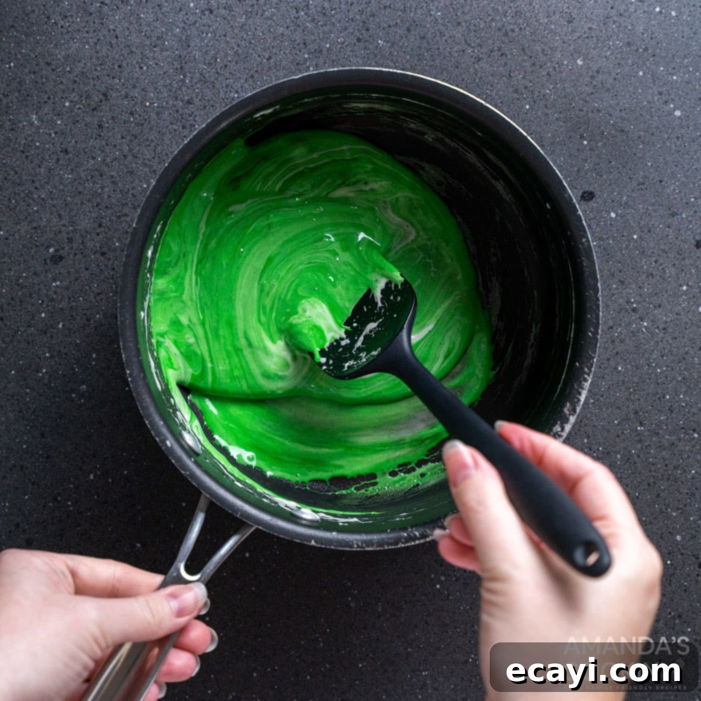 Franken-Crispy Treats 7 spoon stirring green food coloring into melted marshmallows