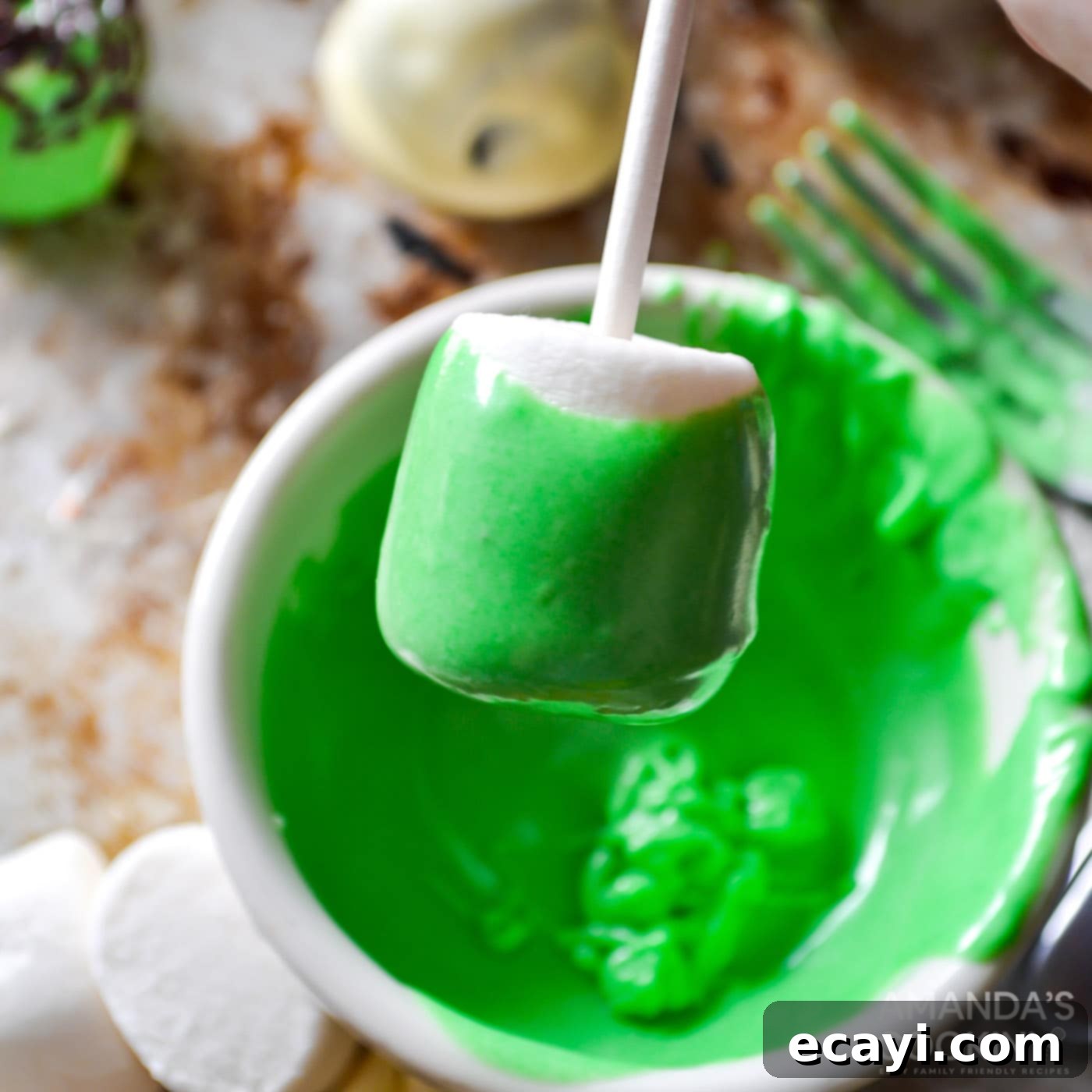Franken-Mallow Creations 5 Dipping a marshmallow into green chocolate coating