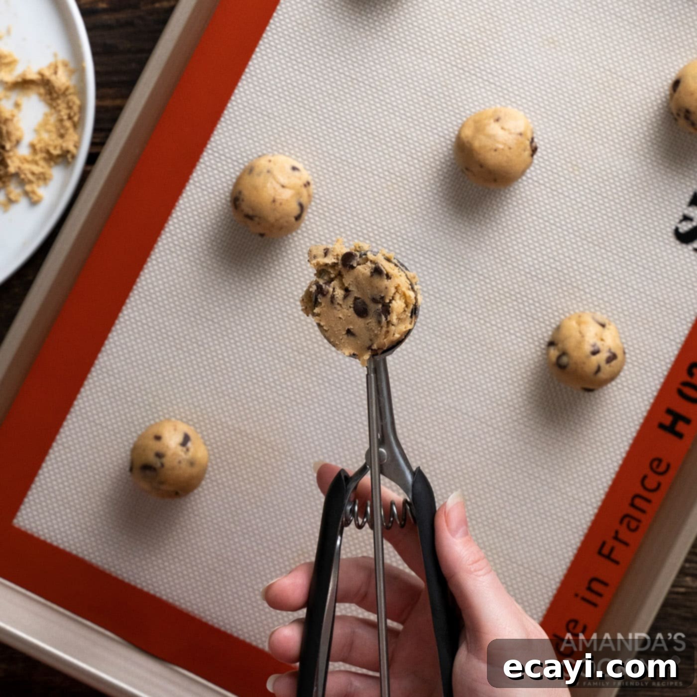 Vampire's Kiss Sandwich Cookies 5 Scooping chocolate chip cookie dough onto a baking sheet