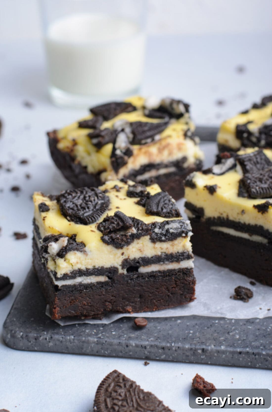 Decadent Oreo Cheesecake Brownies 2 A stunning platter of perfectly cut Oreo Cheesecake Brownies, showcasing the distinct layers of fudgy brownie, creamy cheesecake, and whole Oreos, topped with crushed cookies.