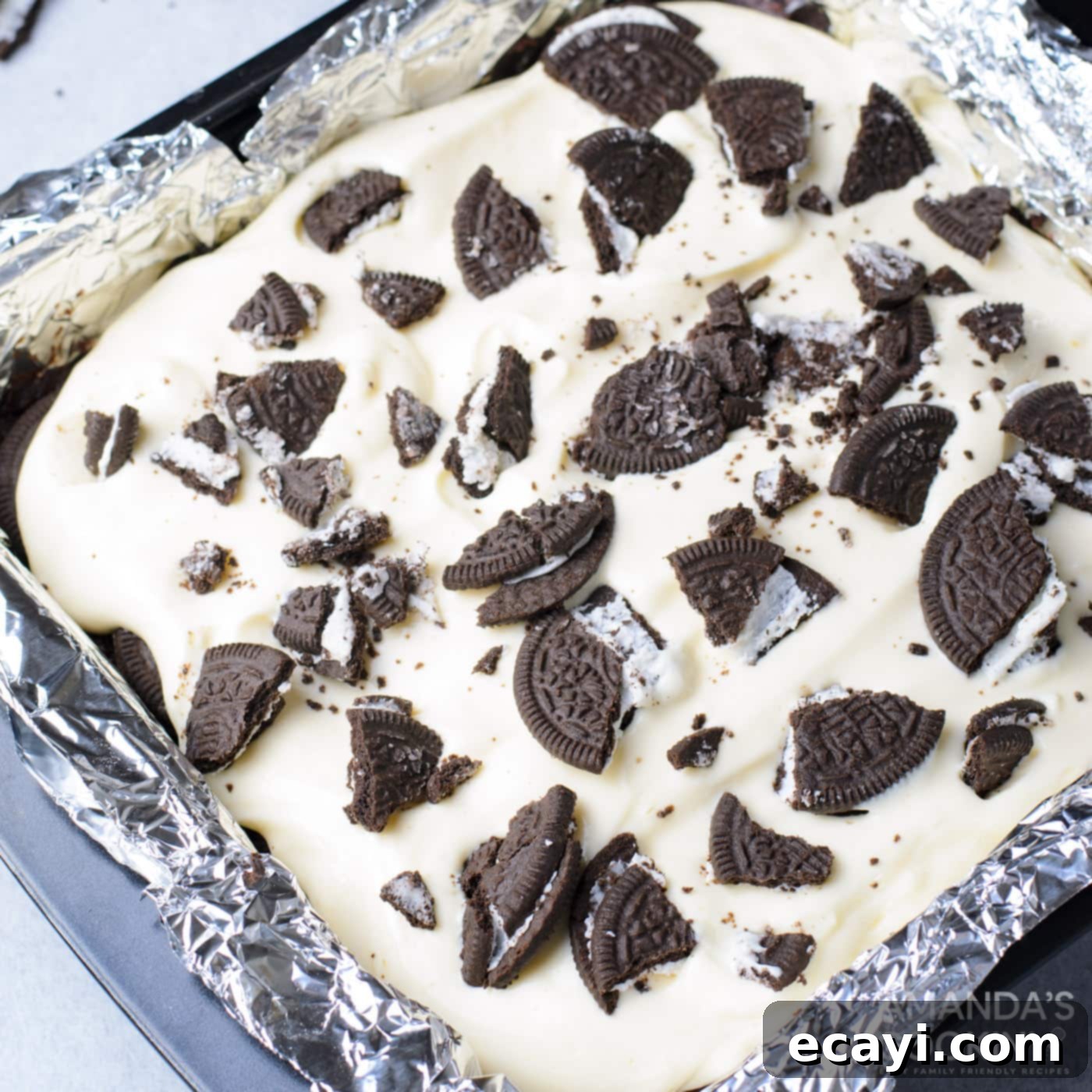 Decadent Oreo Cheesecake Brownies 12 Crushed Oreo cookies generously sprinkled over the creamy cheesecake layer, creating a delicious and visually appealing topping.
