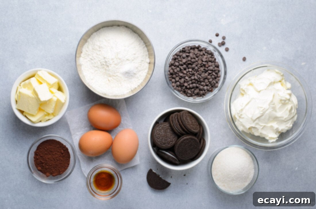 Decadent Oreo Cheesecake Brownies 4 A collection of fresh ingredients laid out on a kitchen counter, including chocolate chips, butter, flour, cocoa powder, sugar, eggs, vanilla extract, cream cheese, and various forms of Oreo cookies, ready for making Oreo Cheesecake Brownies.