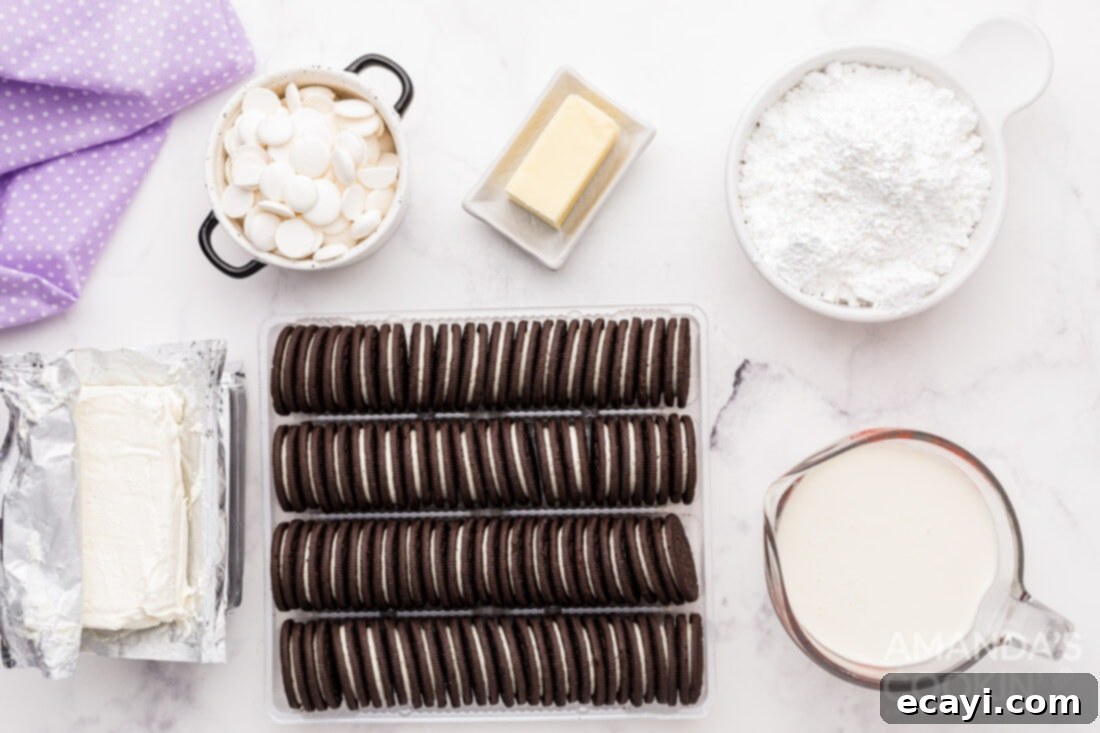 Decadent Oreo Cheesecake 4 All the necessary ingredients laid out for making Oreo Cheesecake, including packages of Oreos, cream cheese, heavy cream, powdered sugar, and white chocolate wafers.