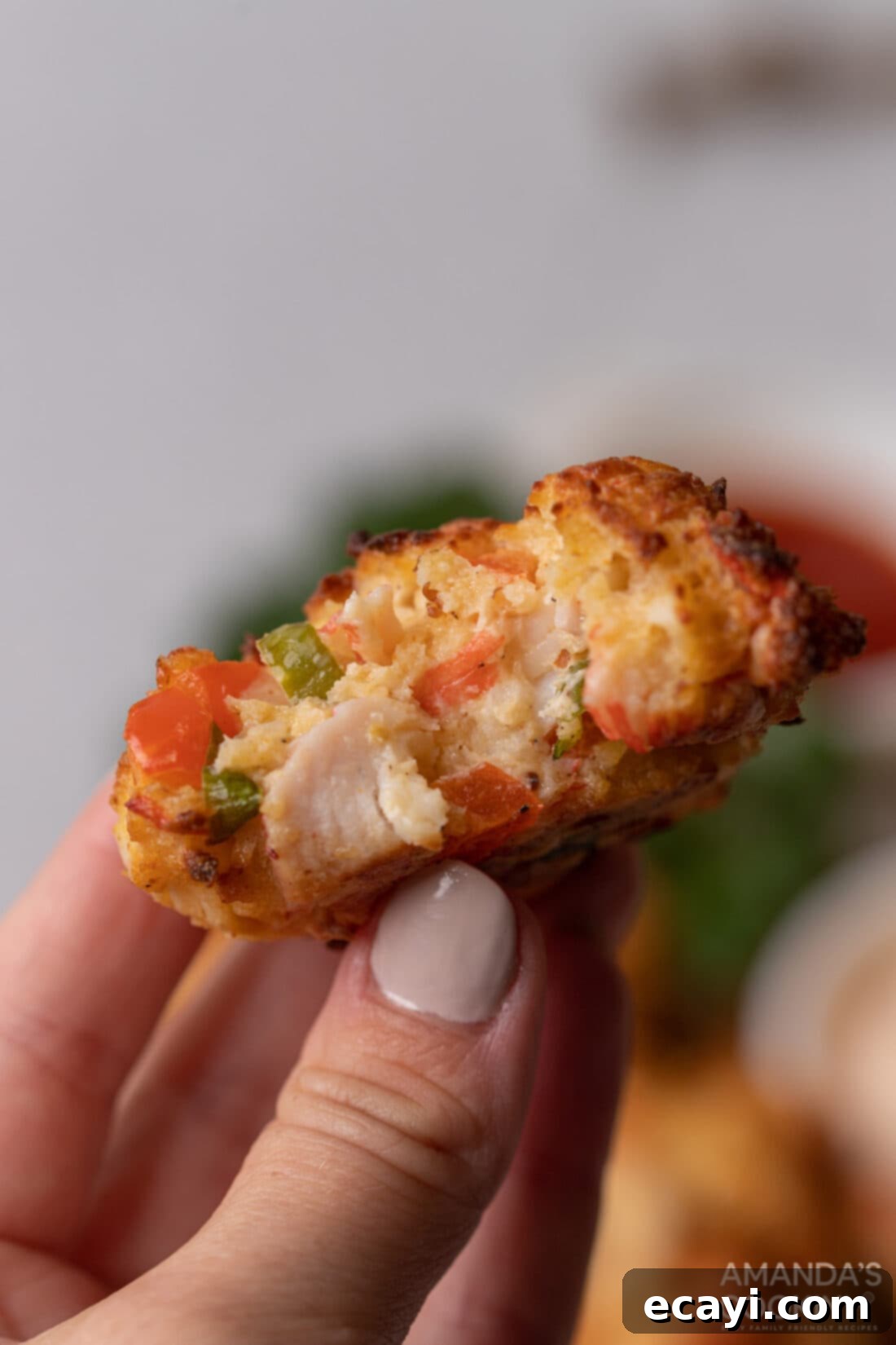 Crispy Air Fryer Crab Cakes 3 holding an Air Fryer Crab Cake with a bite out of it