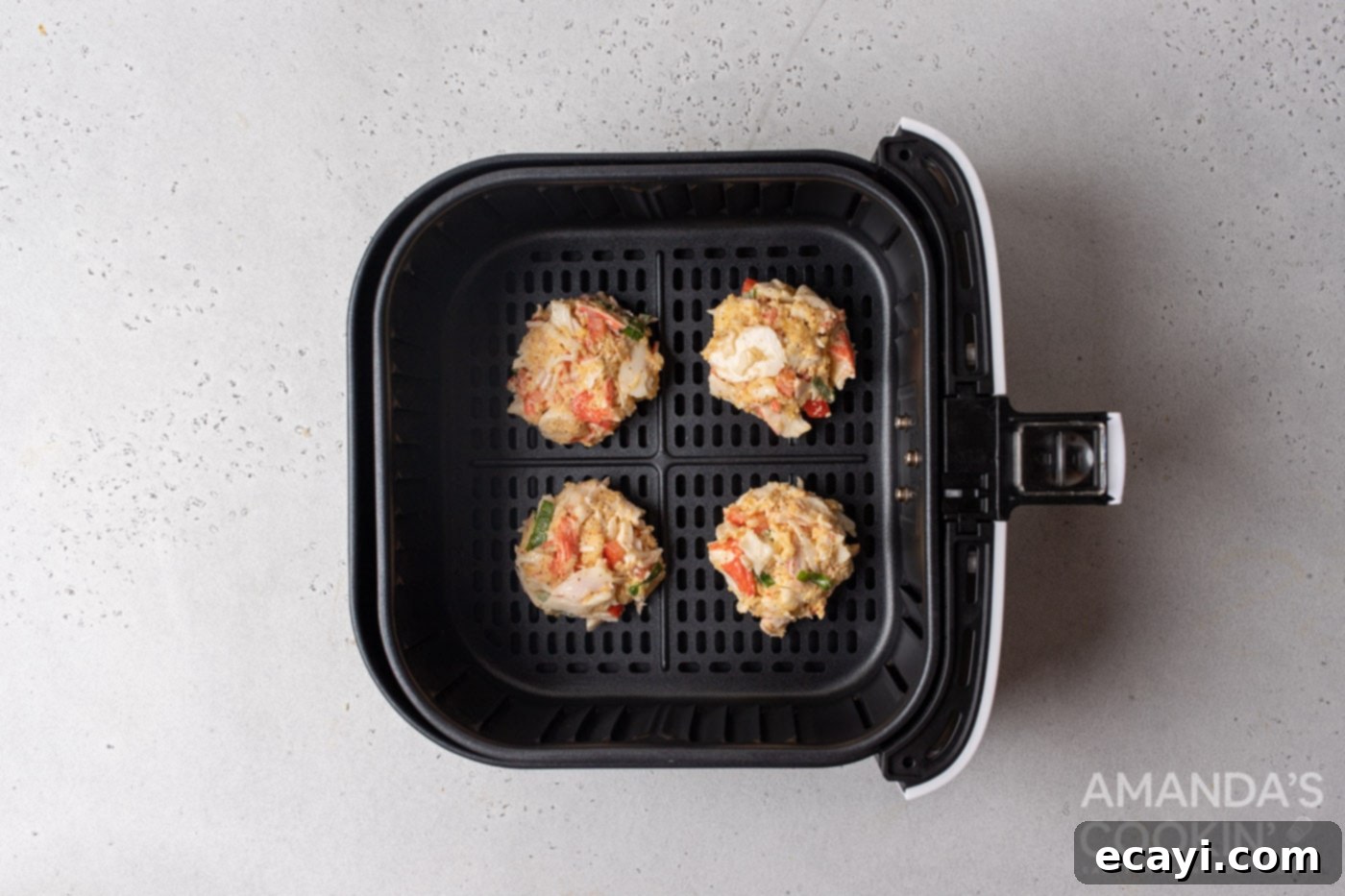Crispy Air Fryer Crab Cakes 7 crab cake patties in an air fryer basket
