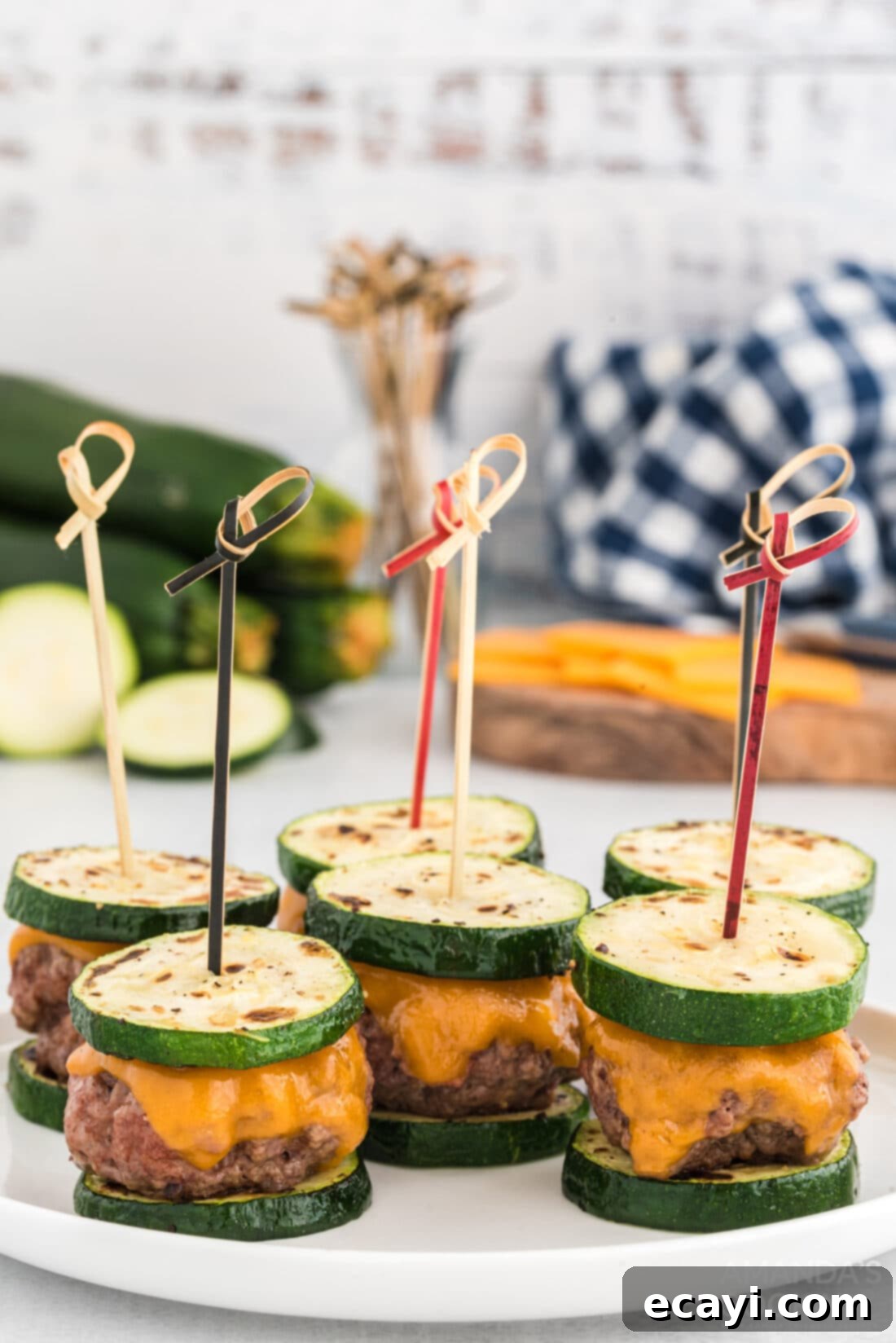 Mini Zucchini Bites 2 Zucchini Sliders with toothpicks, garnished with fresh herbs