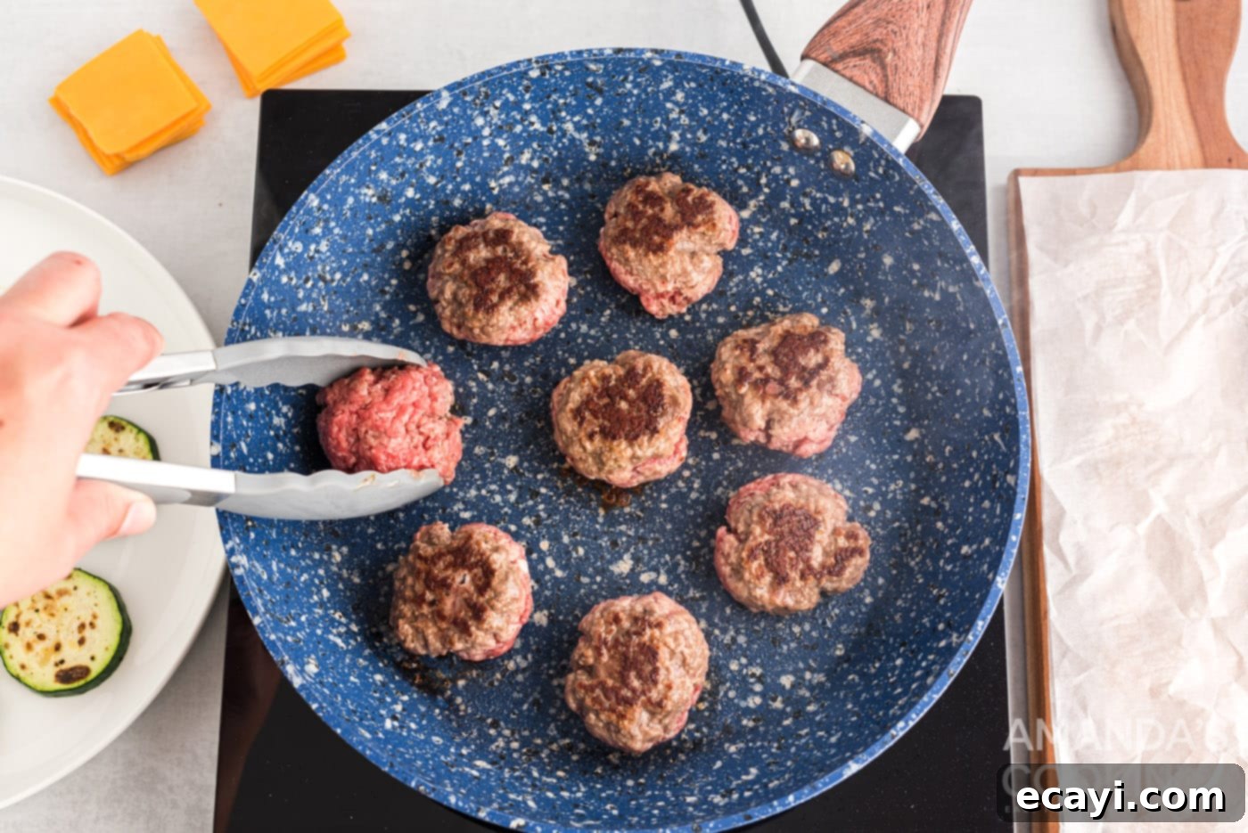 Mini Zucchini Bites 9 tongs flipping burger patty in a skillet, cheese melting
