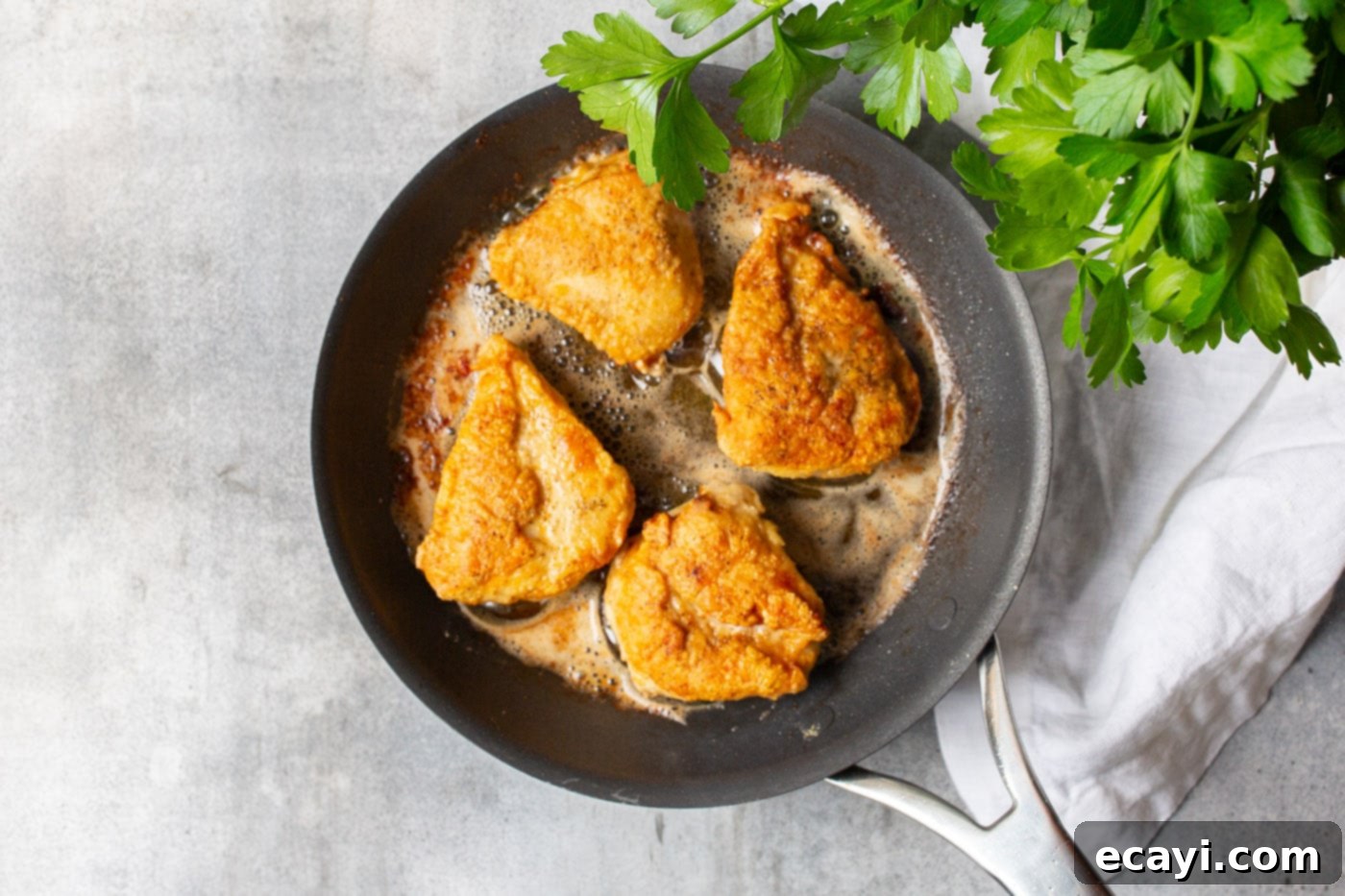 Lemon Caper Chicken 6 Golden brown pan-fried chicken breasts resting on a plate.