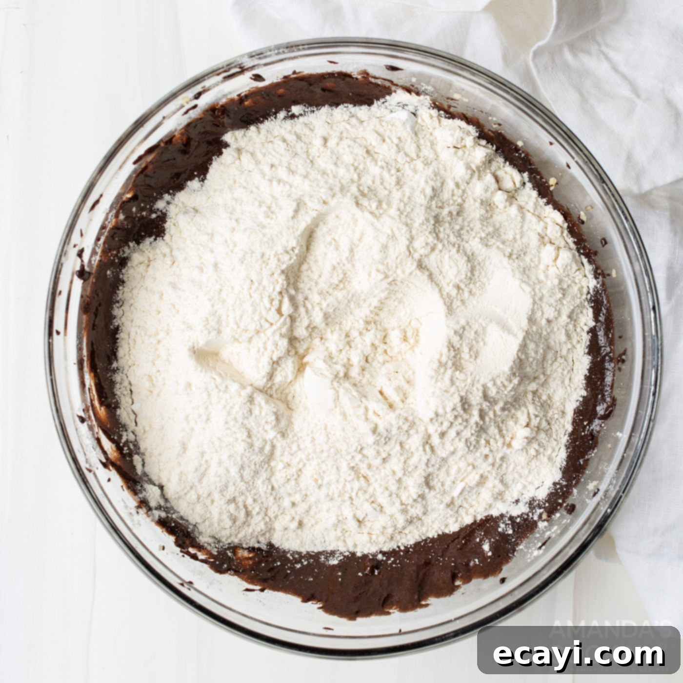 Decadent Coconut Pecan Chocolate Cake 7 Adding flour to the chocolate cake batter in a mixing bowl