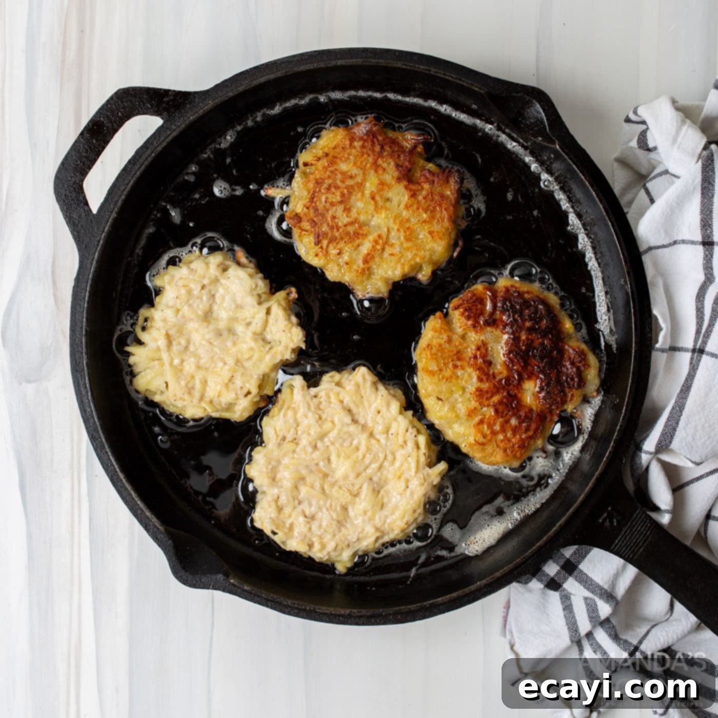 Sizzling Spud Cakes 7 potato pancake patties frying in a pan