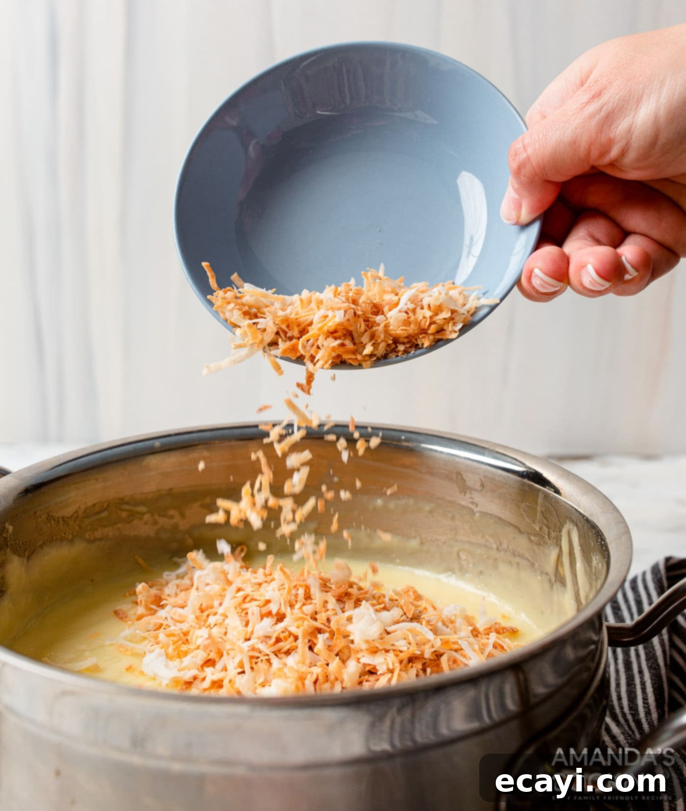 Velvet Coconut Cream Pie 6 adding shredded coconut to coconut custard in a saucepan