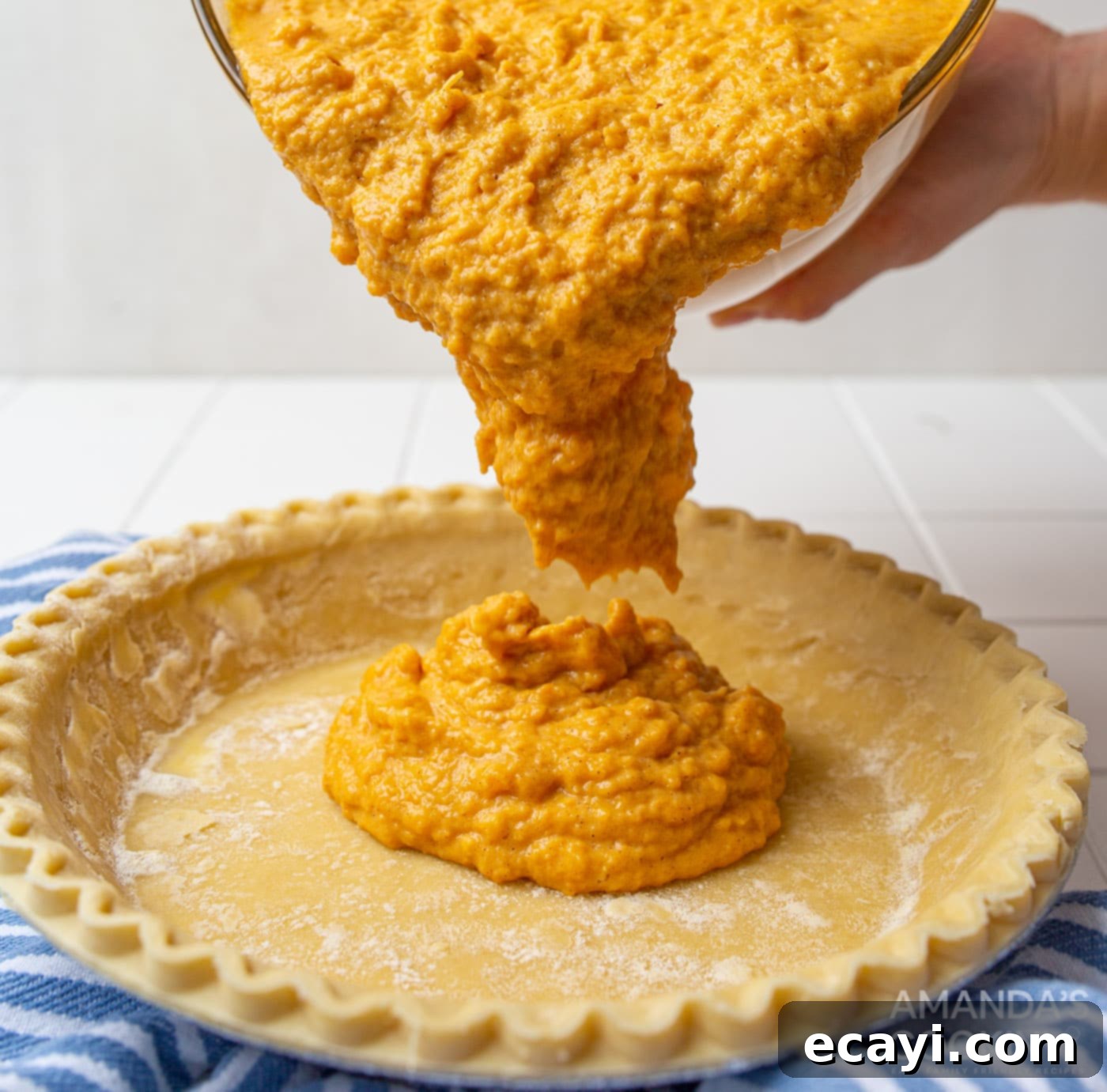 Classic Sweet Potato Pie 6 pouring sweet potato mixture into pie crusts on a baking sheet