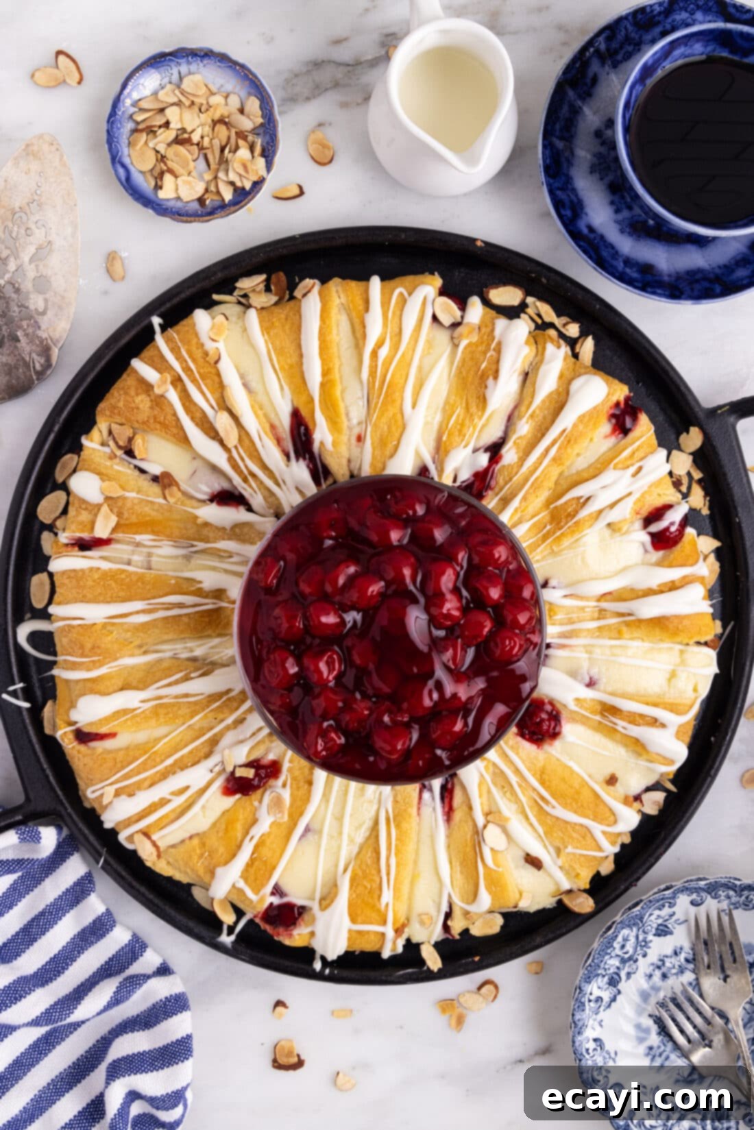 Artisan Danish Wreath 12 Overhead view of a stunning Cherry Cream Cheese Crescent Danish Wreath, freshly baked and iced, ready to be served.
