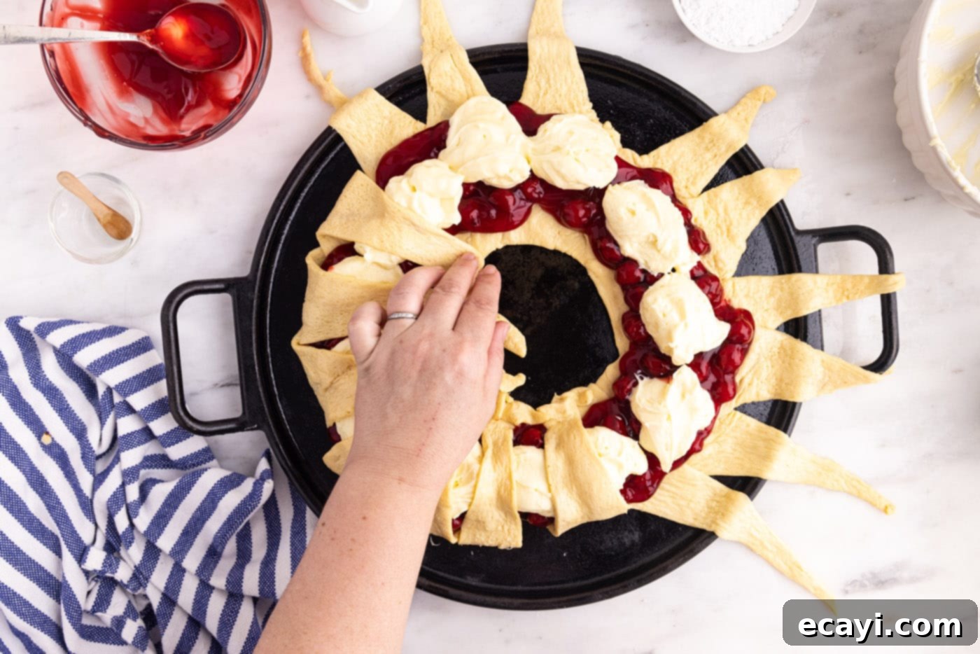 Artisan Danish Wreath 8 Hand carefully folding the pointed ends of crescent rolls over the fillings, creating the wreath shape.