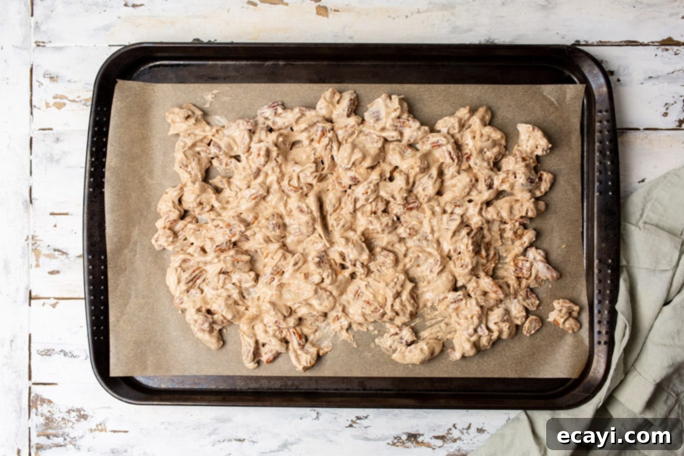 Sweet Pecan Delights 10 Candied pecans spread evenly on a parchment paper-lined baking sheet, ready for the oven