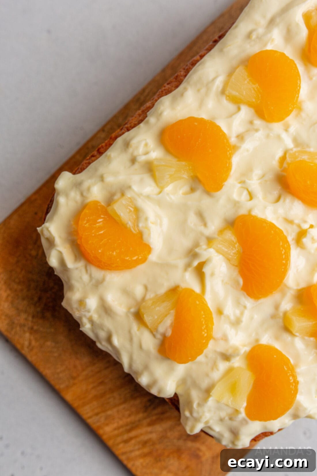 Sunshine Pineapple Orange Cake 3 Overhead view of a beautifully frosted Orange Pineapple Cake with mandarin segments