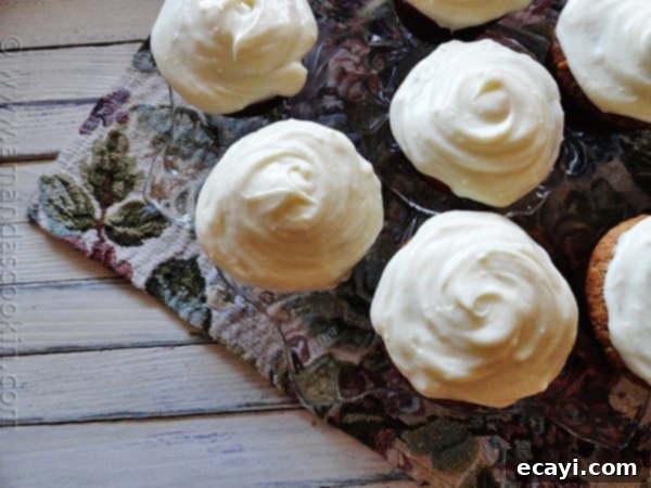 Moist Banana Cupcakes with Decadent Vanilla Cream Cheese Frosting An overhead photo of perfectly baked banana cupcakes with swirl vanilla cream cheese frosting, ready to be enjoyed.