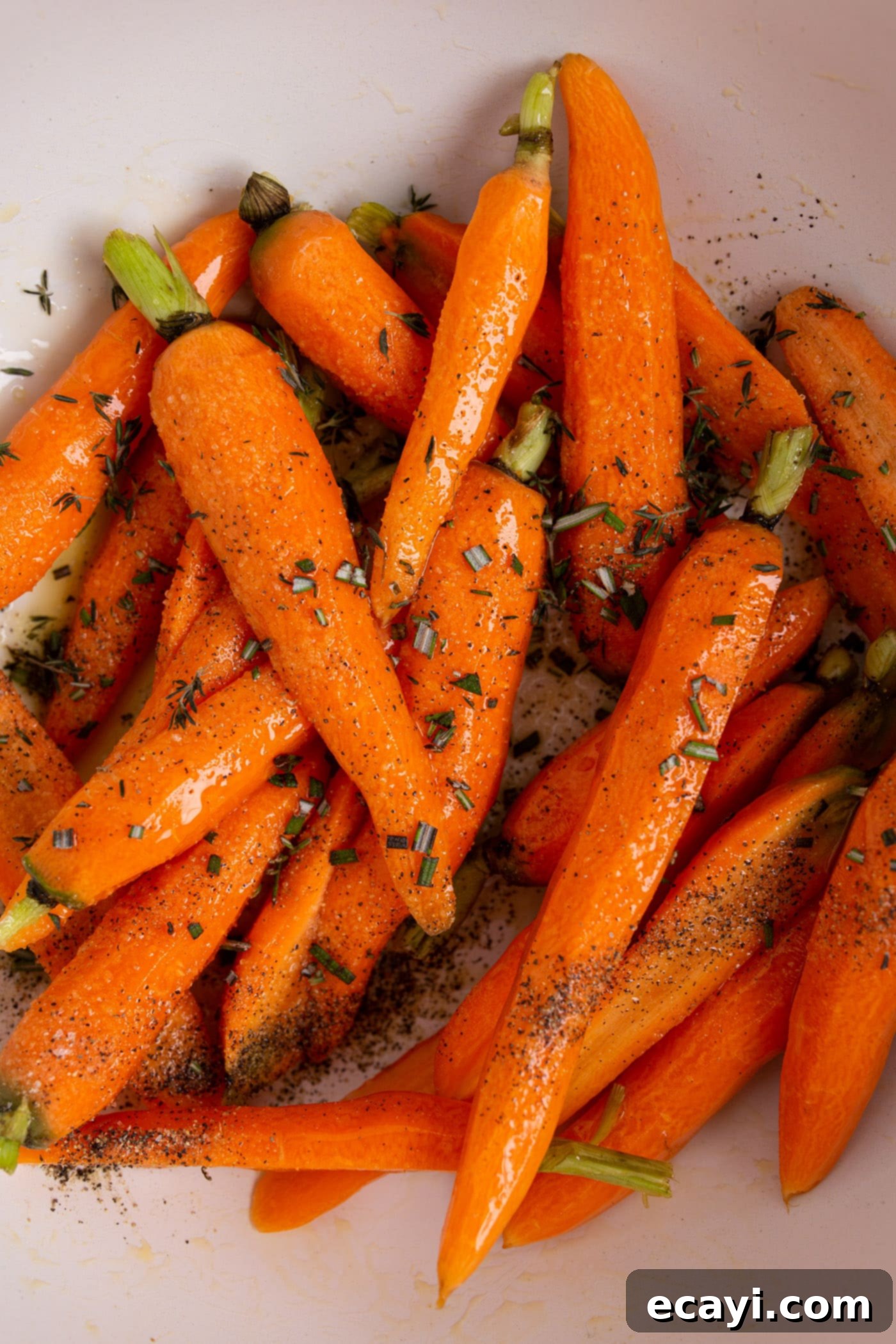 Golden Glazed Carrots 5 carrots in a bowl with seasonings, ready for roasting