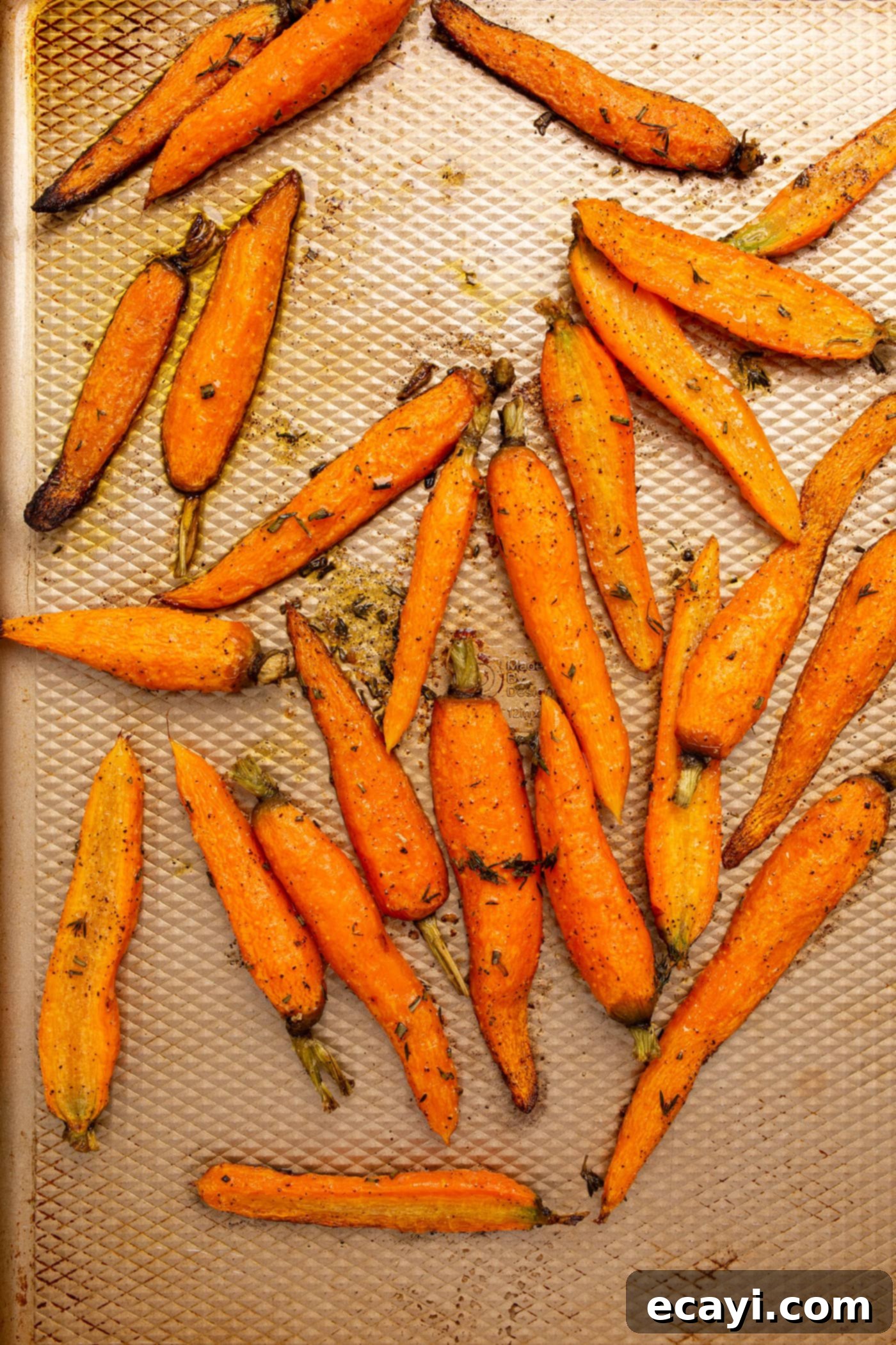 Golden Glazed Carrots 6 roasted carrots on a baking sheet, golden and tender
