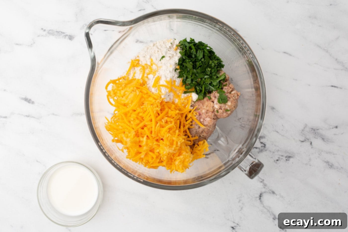 Savory Sausage Bites 5 Sausage ball ingredients in a mixing bowl being combined