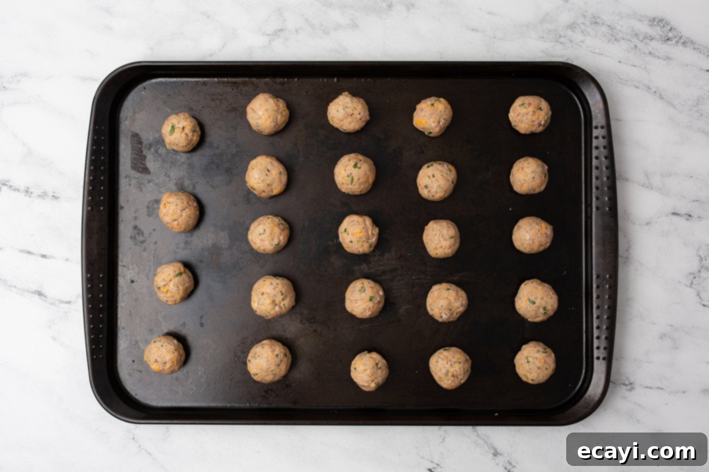 Savory Sausage Bites 7 Raw sausage balls neatly arranged on a baking sheet