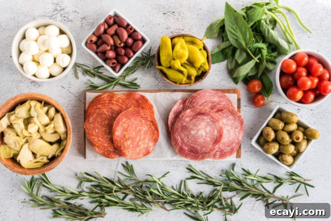 Gourmet Grazing Wreath 4 A selection of fresh ingredients including mozzarella balls, basil, cherry tomatoes, salami, prosciutto, and olives, laid out for an Antipasto Wreath.