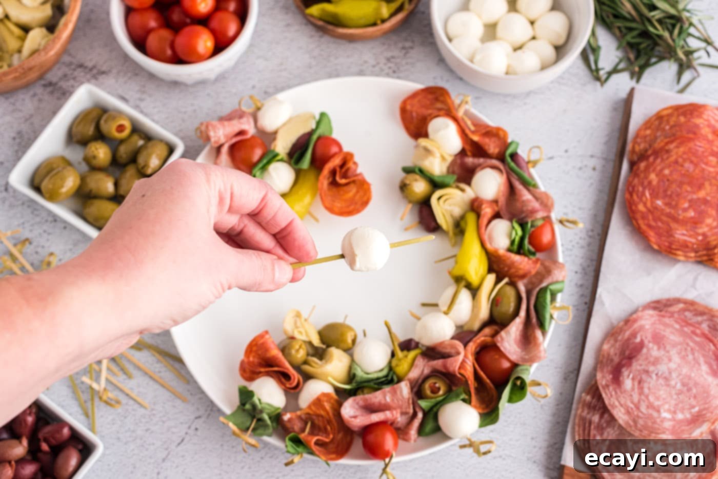 Gourmet Grazing Wreath 5 A single skewer with a mozzarella pearl, basil leaf, and olive, demonstrating the assembly process for the Antipasto Wreath.