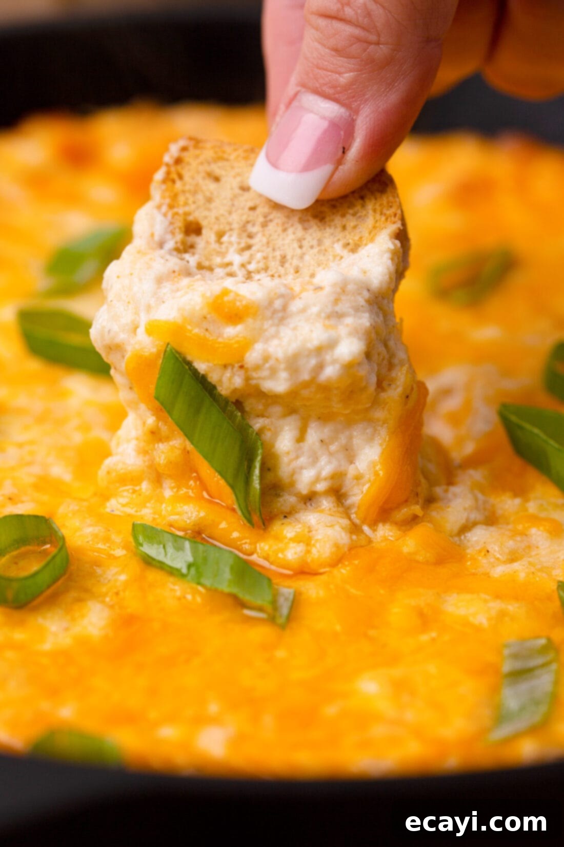 Decadent Crab Dip 3 scooping creamy crab dip from a serving bowl