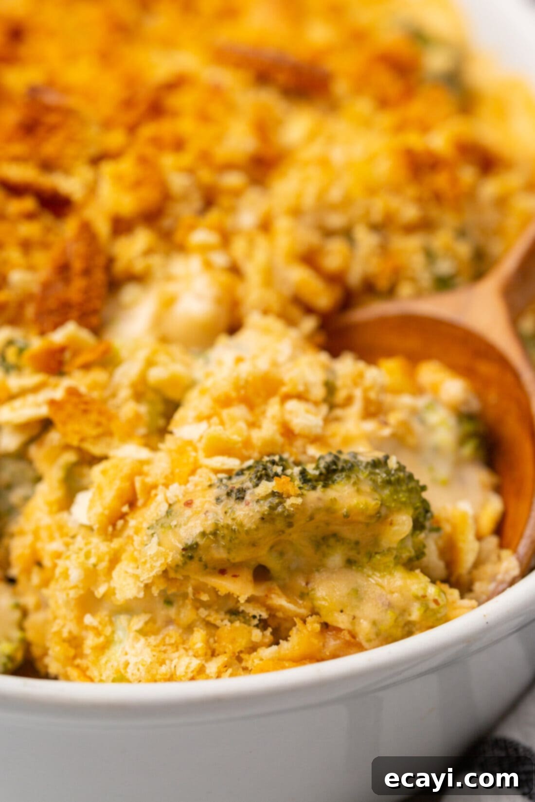 Cheesy Broccoli Bake 2 wooden spoon in dish of Broccoli Casserole