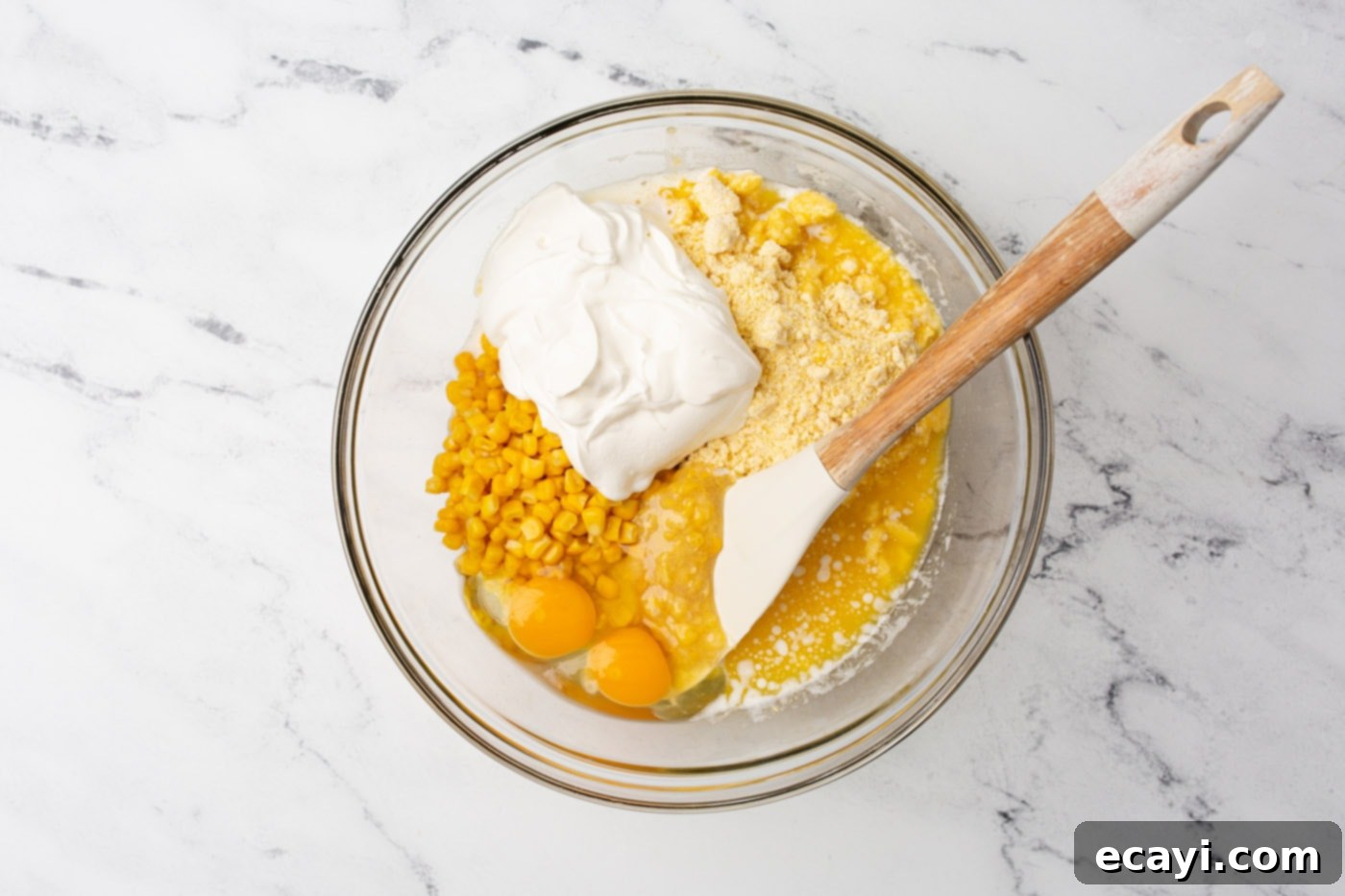 Golden Corn Bake 5 mixing corn casserole ingredients in a bowl