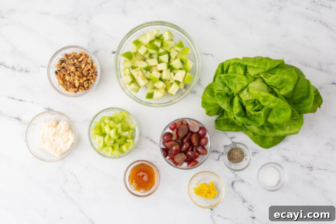 Crisp Apple Walnut Delight 4 A collection of fresh ingredients laid out on a table, including apples, grapes, celery, walnuts, and dressing components for Waldorf Salad.
