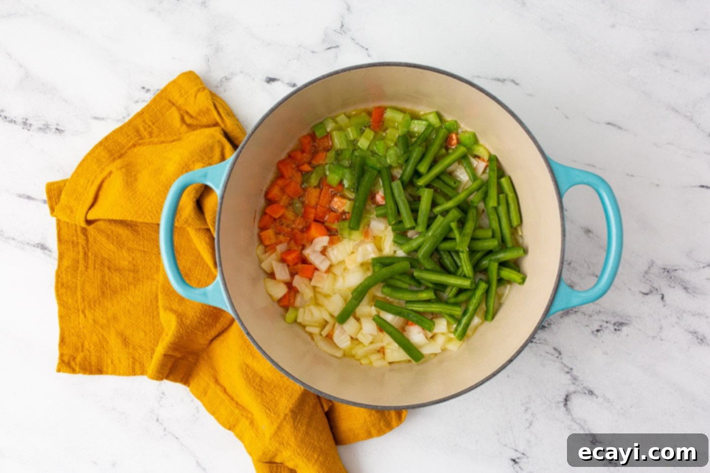 Rustic Italian Minestrone 5 Sautéing diced onions, carrots, celery, and green beans in a large stockpot for minestrone soup