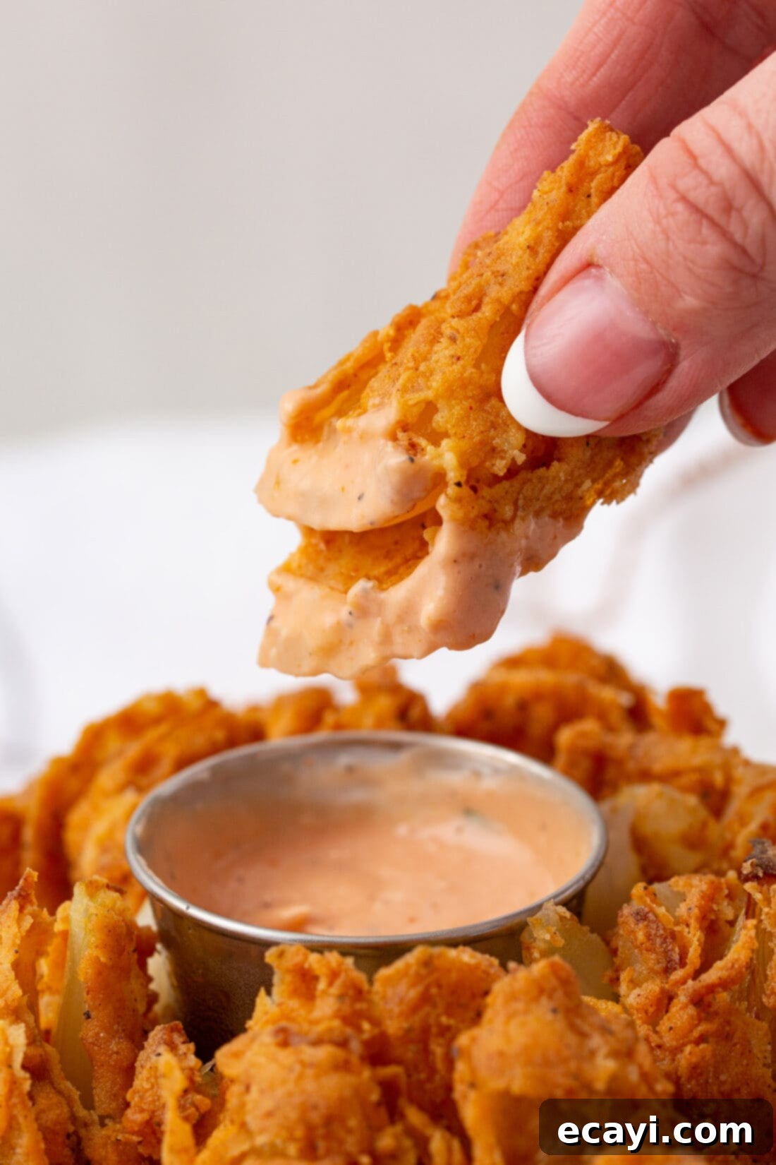 Blooming Onion 3 dipping a piece of Blooming Onion