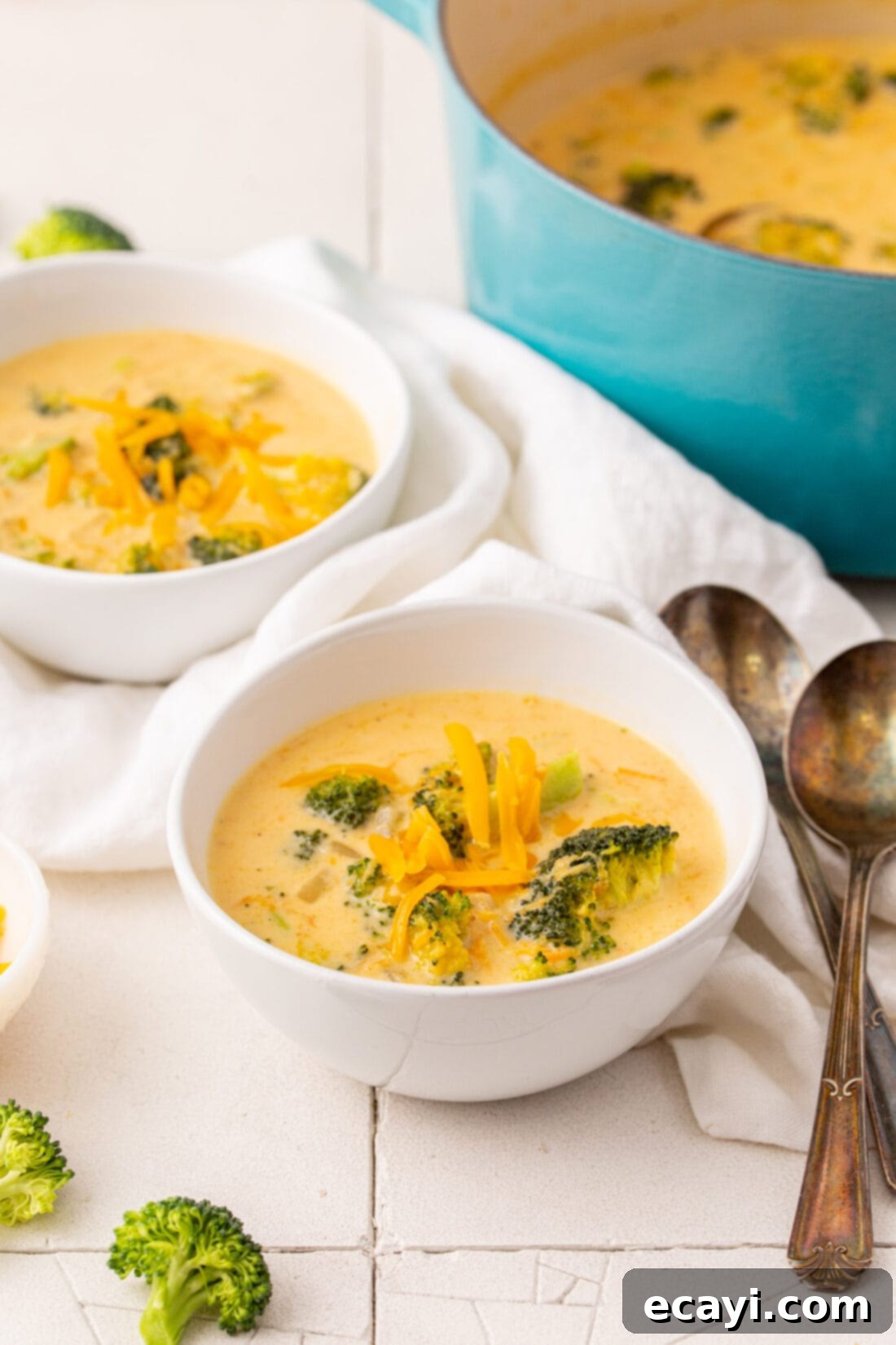 Golden Broccoli Cheddar Delight 3 A cozy bowl of creamy broccoli cheese soup, garnished with fresh shredded cheddar cheese.