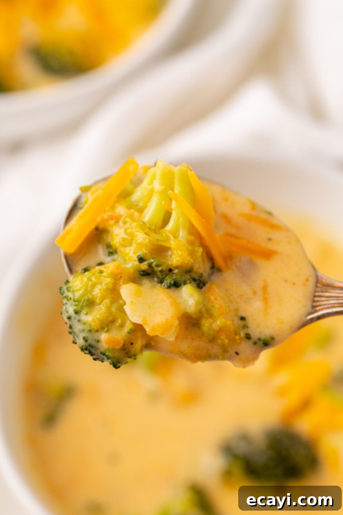 Golden Broccoli Cheddar Delight 8 A spoonful of rich, creamy broccoli cheese soup, showing the tender broccoli and melted cheddar.