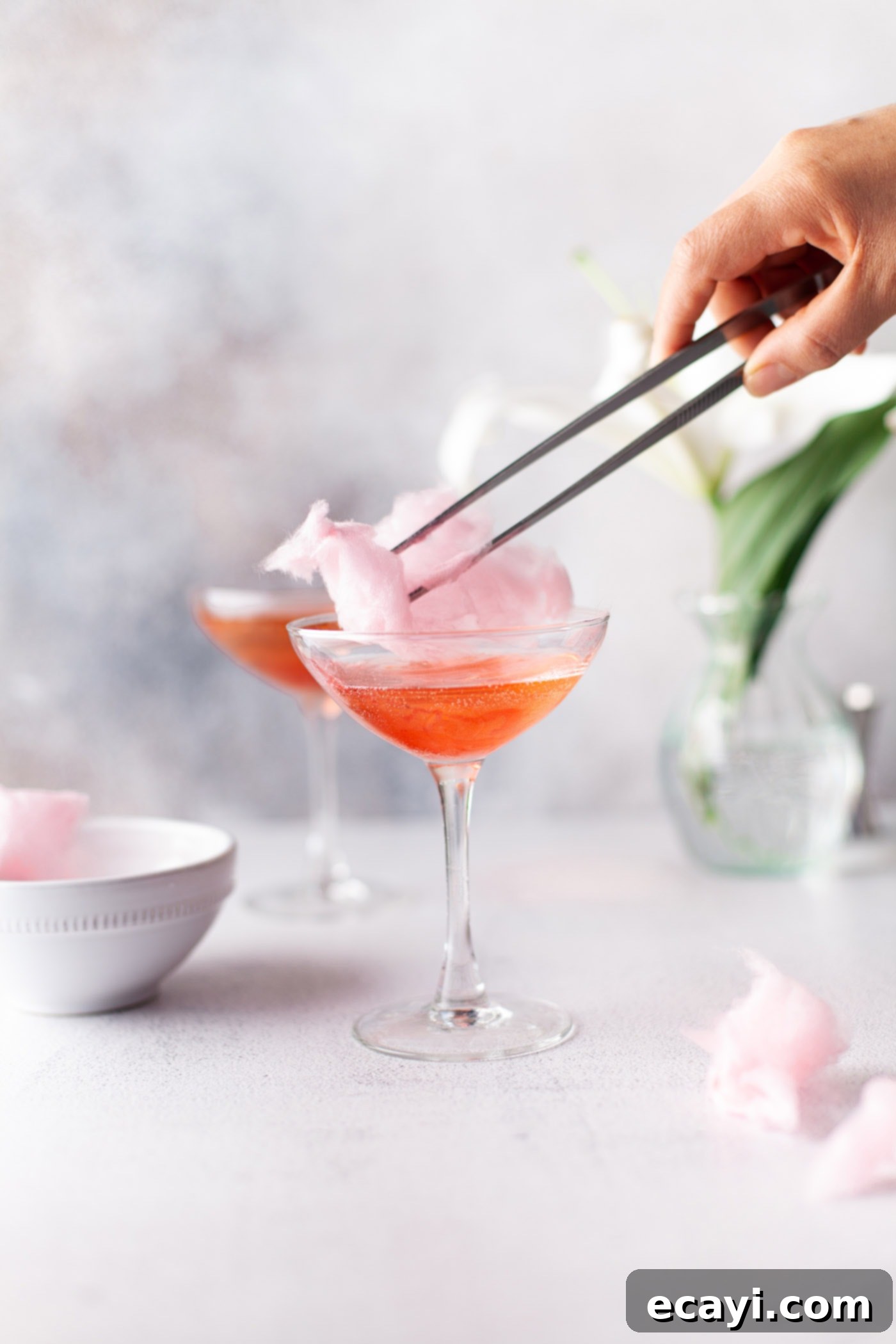 Whimsical Effervescence 6 chopsticks adding cotton candy to the top of a glass for garnish