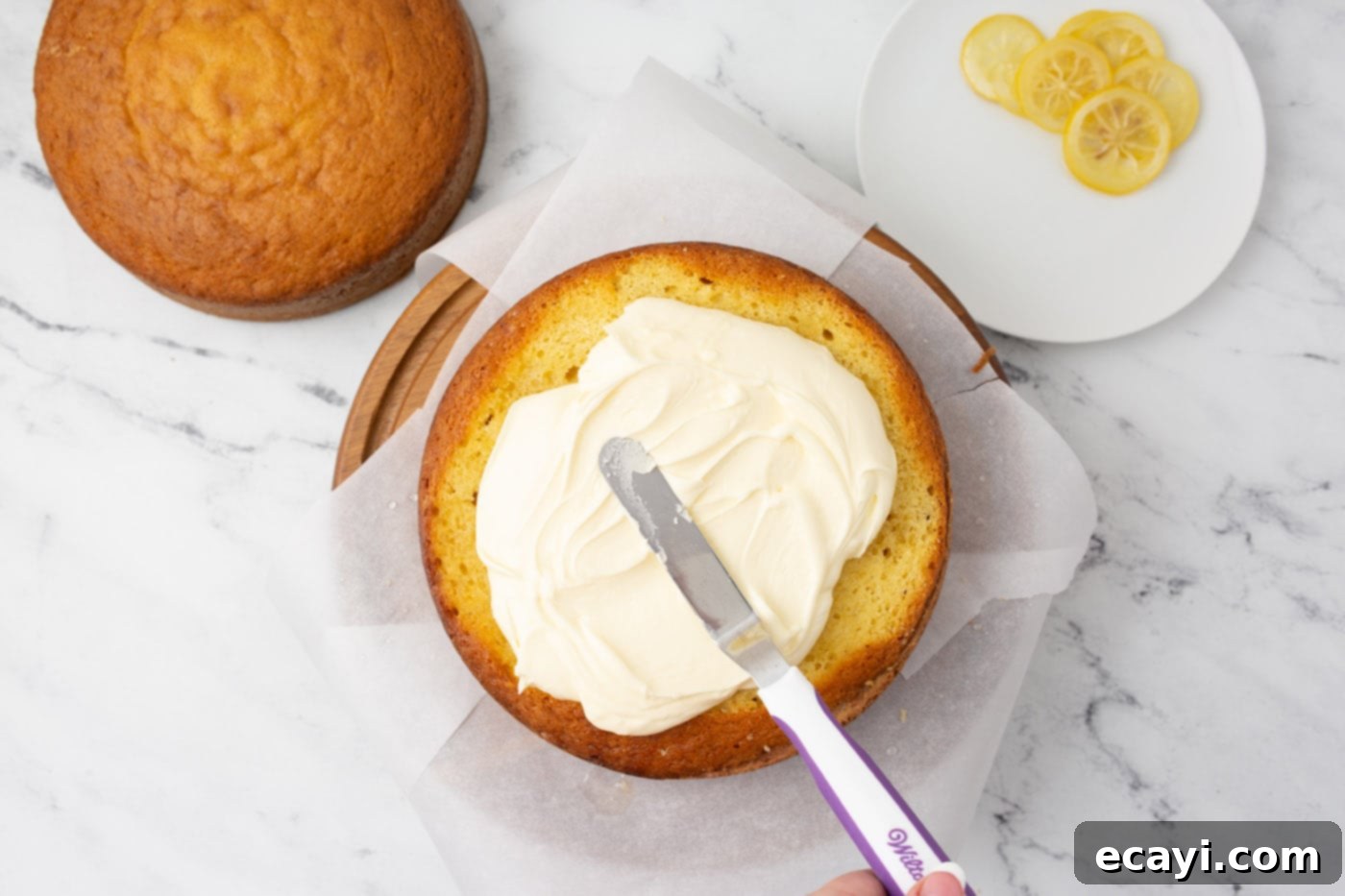 Bright Lemon Bliss 12 icing spatula spreading frosting onto cake