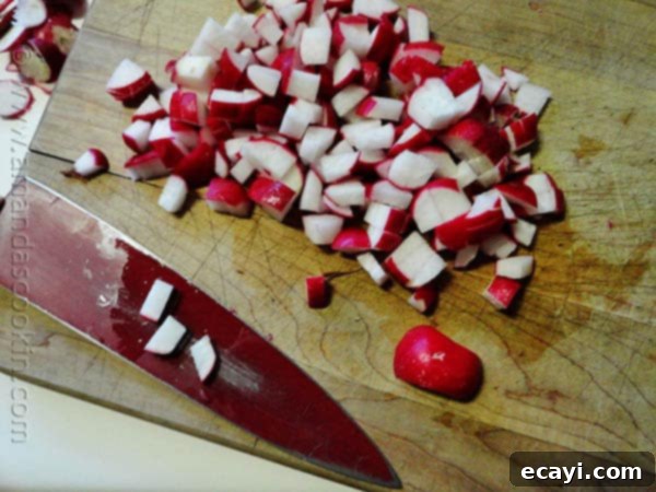 Radish Hash Browns A close up photo of chopped radish on a wooden cutting board with a knife on the side.