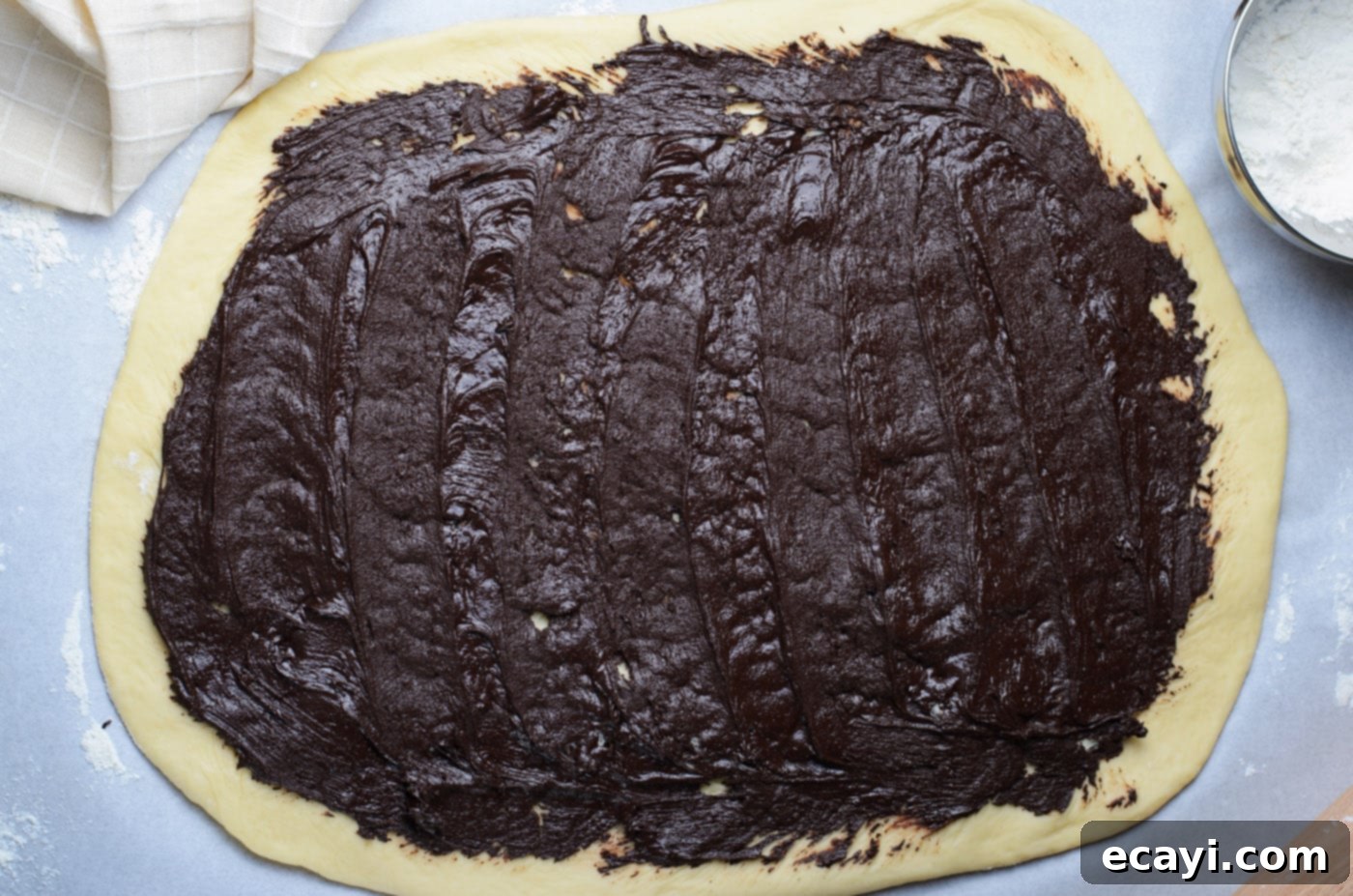 Swirling Chocolate Delight 11 Spreading the decadent chocolate filling smoothly and evenly over the rolled-out babka dough, leaving a clean border.