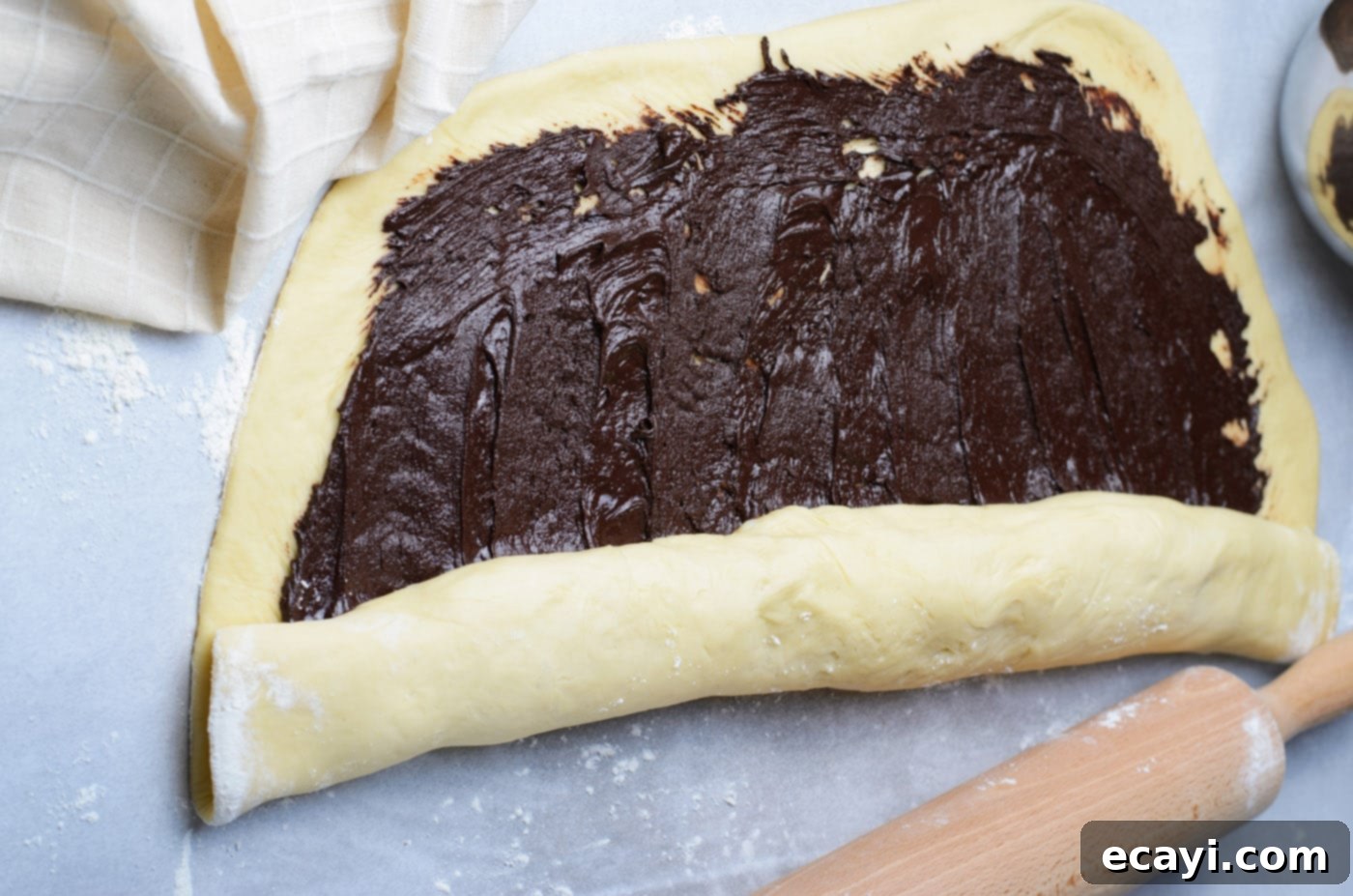 Swirling Chocolate Delight 12 Tightly rolling the chocolate-filled babka dough into a long, even log, ready for slicing.