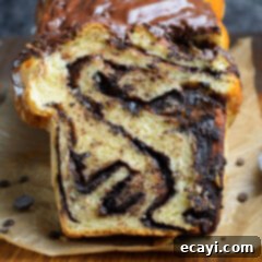 Swirling Chocolate Delight 17 A freshly baked Chocolate Babka loaf, beautifully glazed and ready to be sliced, perfect for a sweet treat.