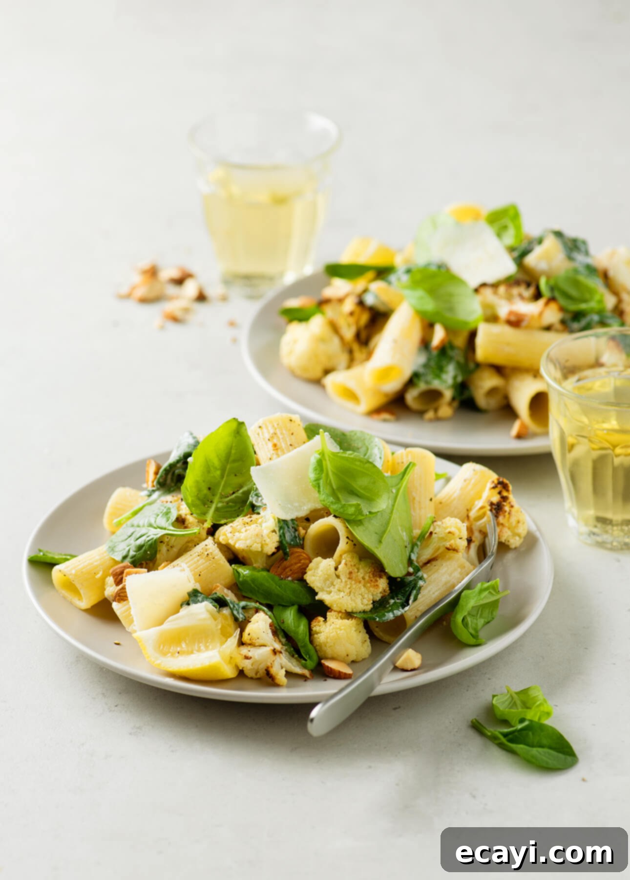 Lemon Roasted Cauliflower Pasta 4 A serving of lemony broiled cauliflower pasta in a bowl, with a fork digging in.