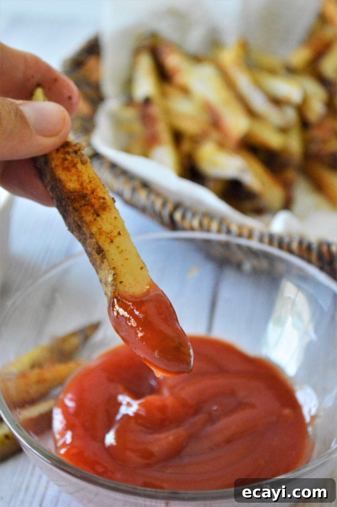 Oven Fries 3 Dipping a golden baked French fry into a dollop of vibrant red ketchup