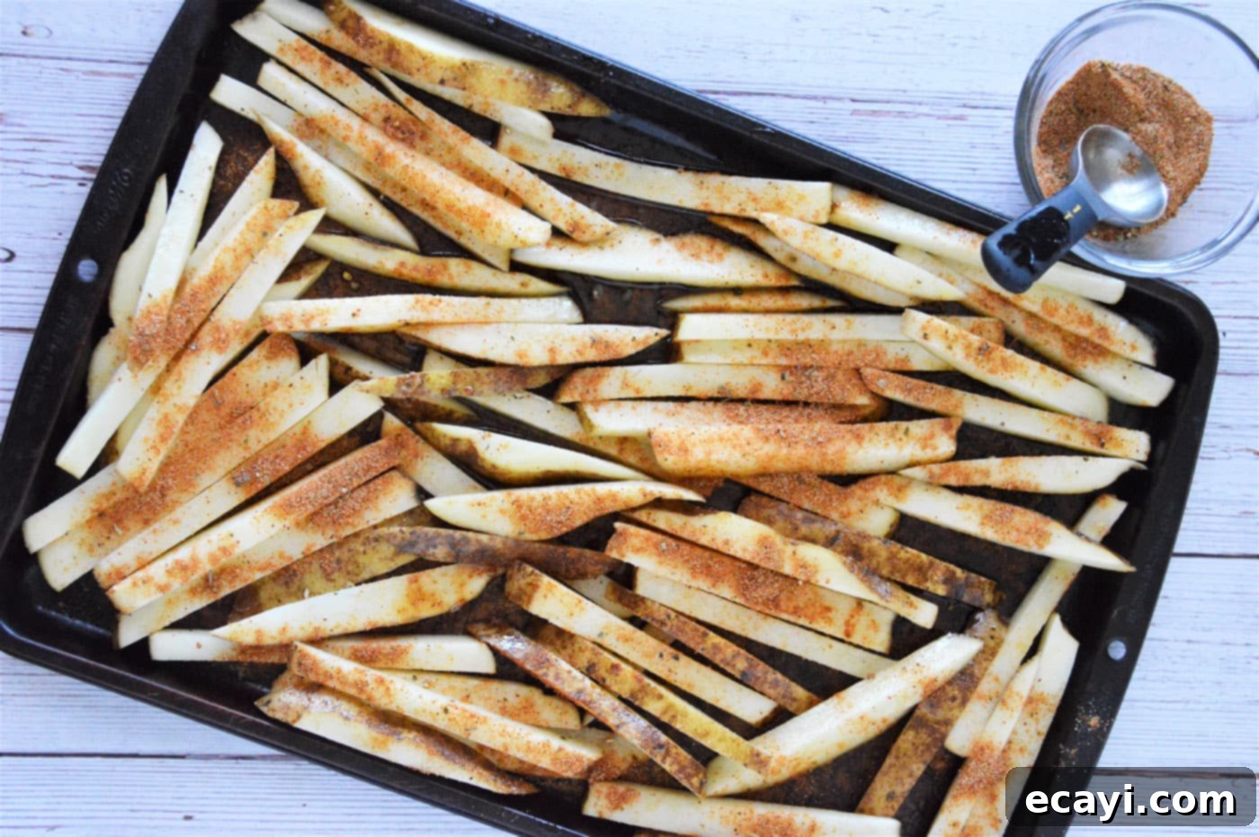 Oven Fries 6 Baked French fries spread out evenly on a baking tray after their first bake, ready for the crisping stage