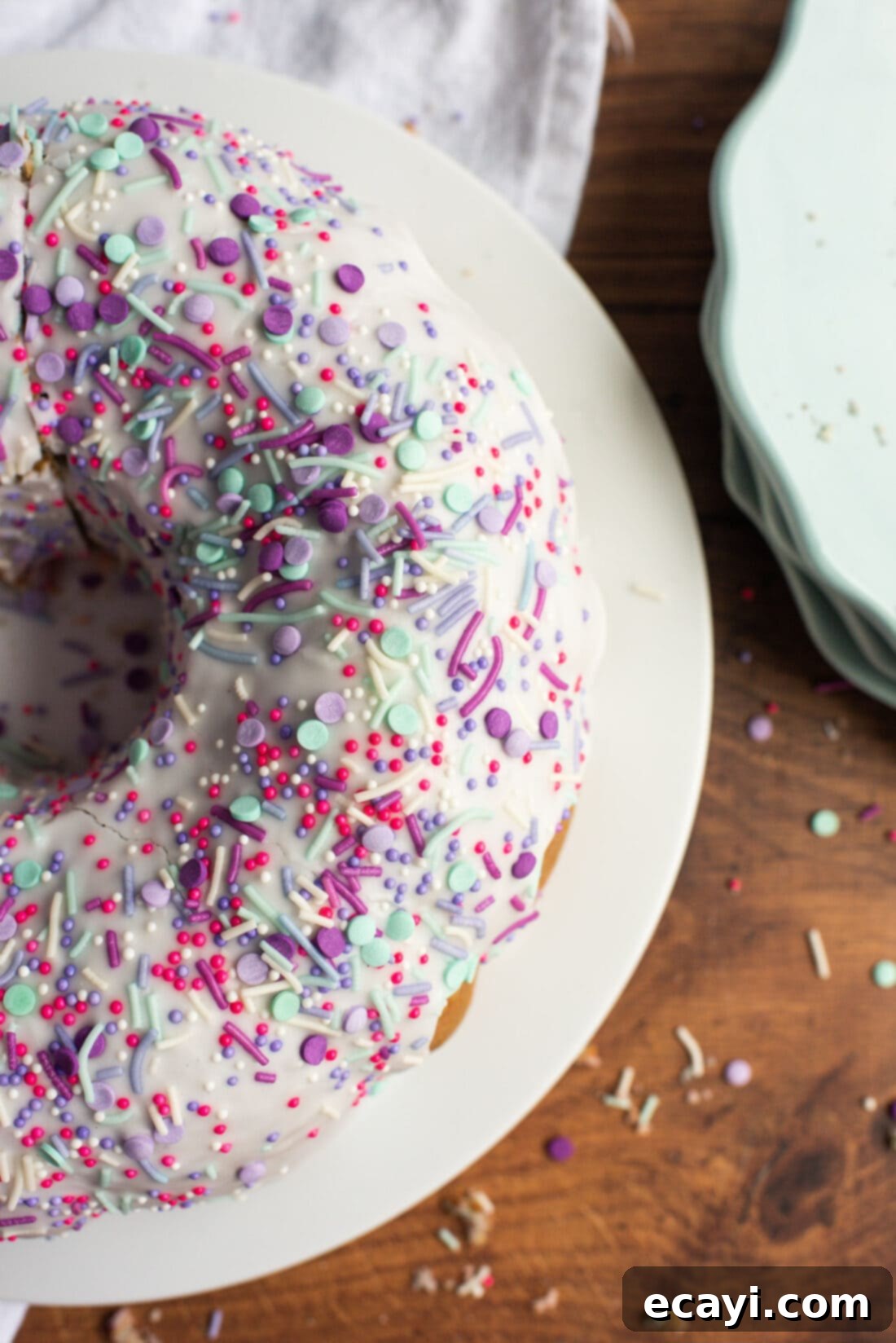Enchanted Rainbow Bundt 2 Overhead view of a beautiful Unicorn Bundt Cake with pastel swirls and colorful sprinkles.
