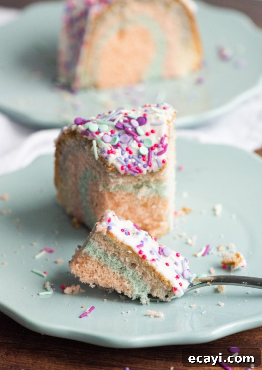 Enchanted Rainbow Bundt 13 A freshly cut slice of Unicorn Bundt Cake showing the multi-colored layers.