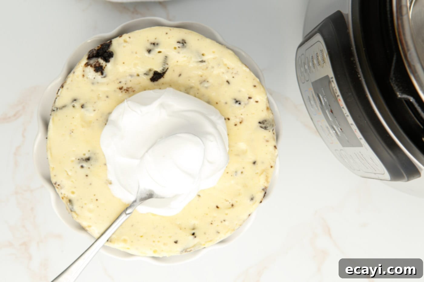 Instant Pot Oreo Cheesecake 9 spreading whipped cream on oreo cheesecake
